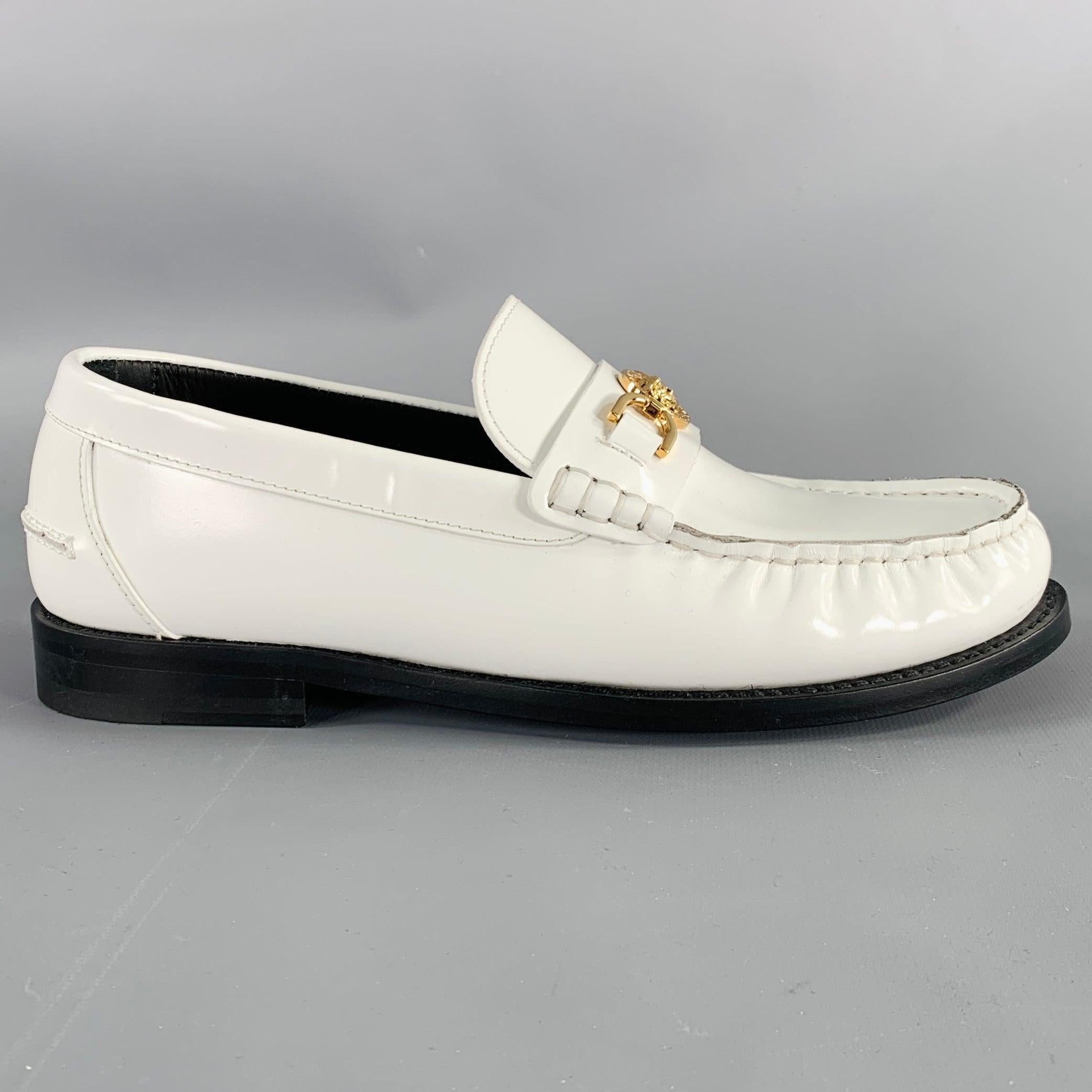 Sandales VERSACE
en cuir blanc, avec un style mocassin, des détails en métal doré en forme de tête de Méduse et une fermeture à glissière. Livré avec un sac à poussière. Fabriqué en Italie. Excellent état. 

Marqué :   3592 39Semelle : 10.25 pouces 