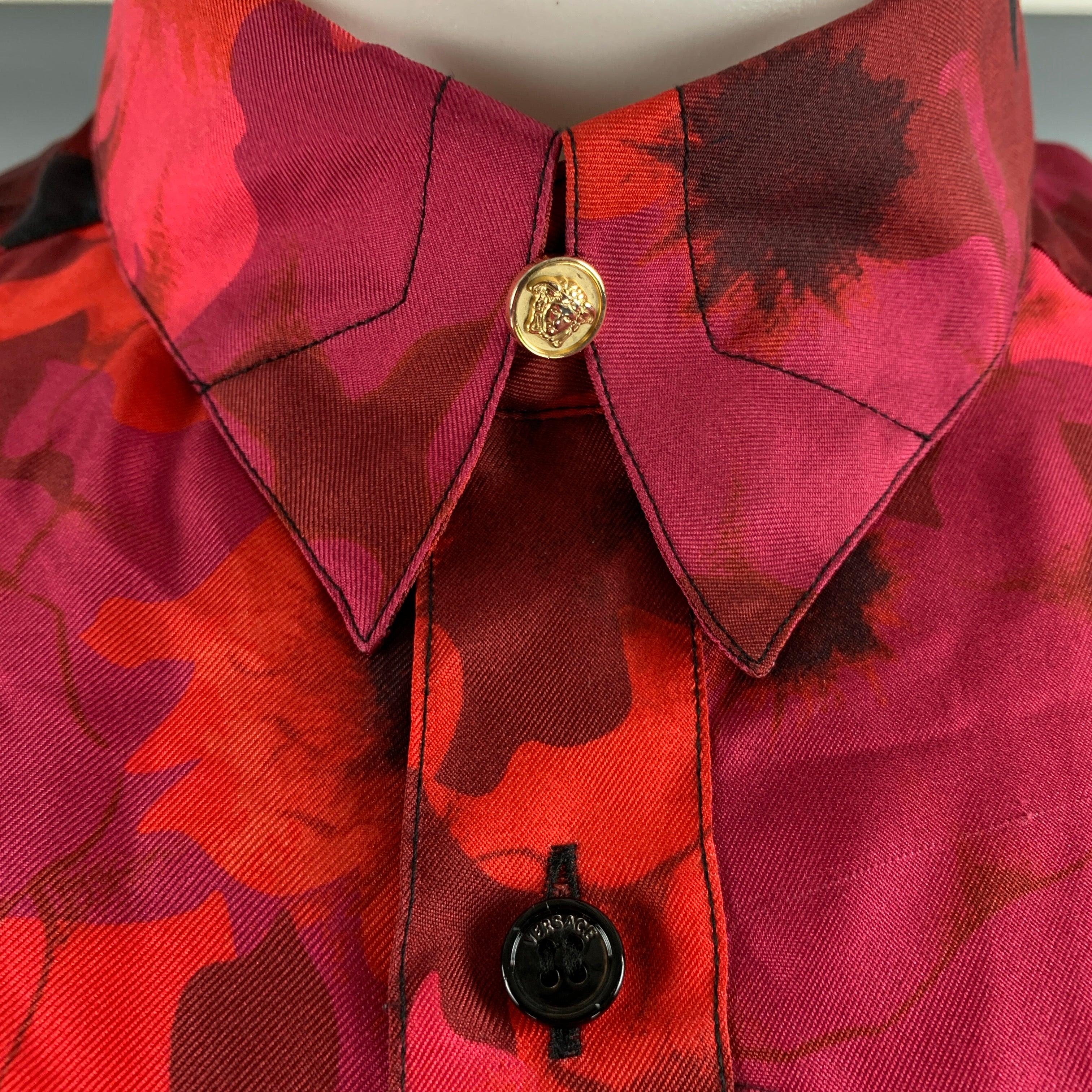La chemise à manches longues VERSACE VINTAGE est réalisée en soie tissée à imprimé floral noir et multicolore. Elle présente une épaule tombante, des boutons à tête de méduse dorés, un col droit et se ferme par un bouton. Fabriqué en Italie. Bon