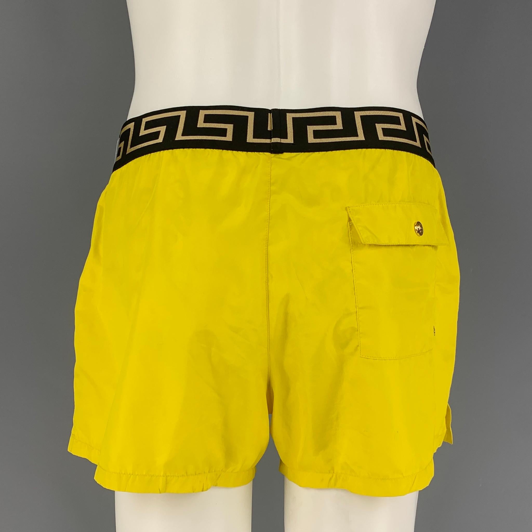VERSACE swim trunks comes in a yellow & black nylon featuring a mesh liner and a elastic waistband. Made in Italy. 

Very Good Pre-Owned Condition.
Marked: 5

Measurements:

Waist: 30 in.
Rise: 11.5 in.
Inseam: 3.5 in. 