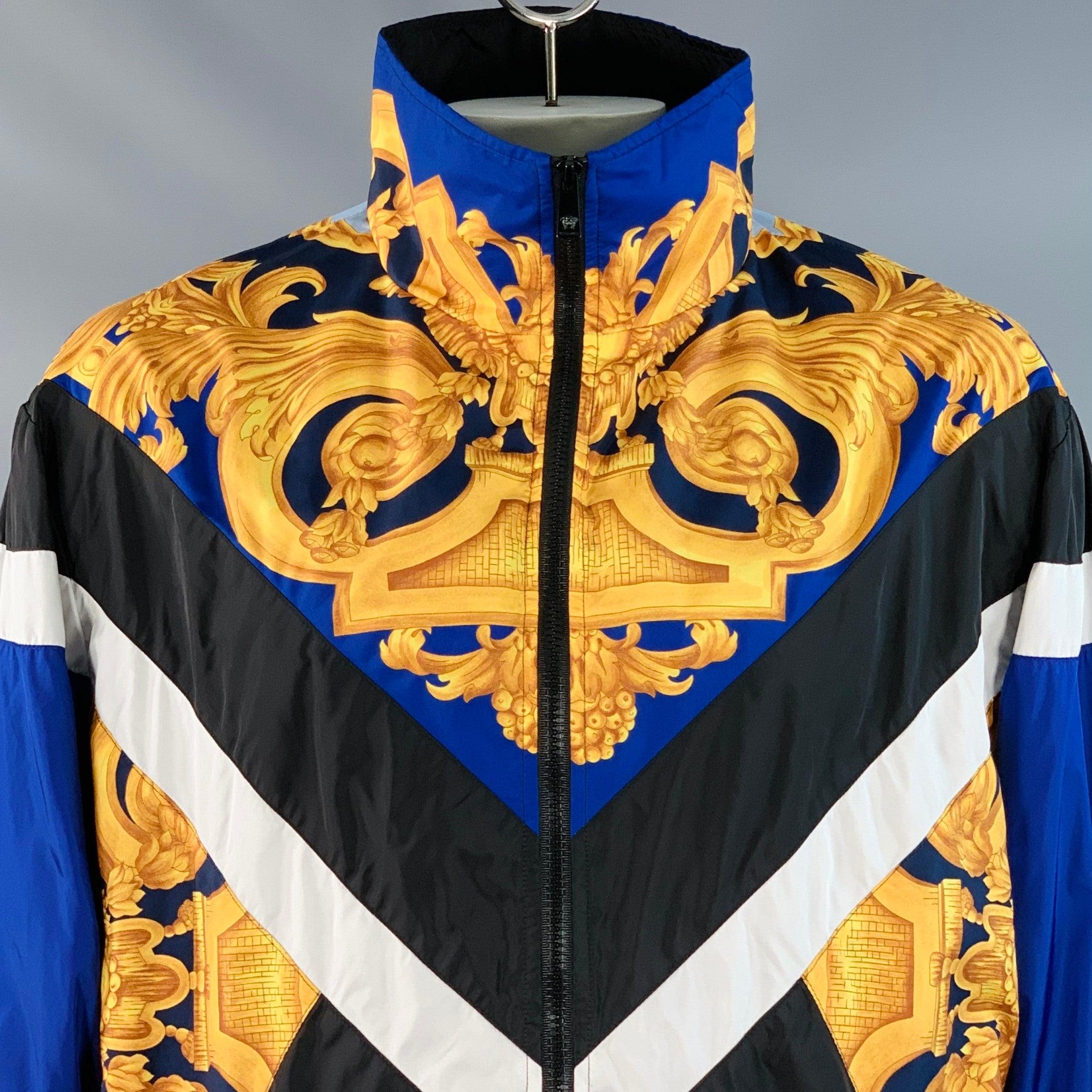 VERSACE Jacke
aus schwarzem, blauem und goldfarbenem Polyamid-Gemisch mit Farbblock-Design und Barockdruck auf Vorder- und Rückseite, zwei Druckknopftaschen und Reißverschluss. 

Markiert:   IT 54 

Abmessungen: 
 
Schulter: 20,5 Zoll Brust: 58 Zoll