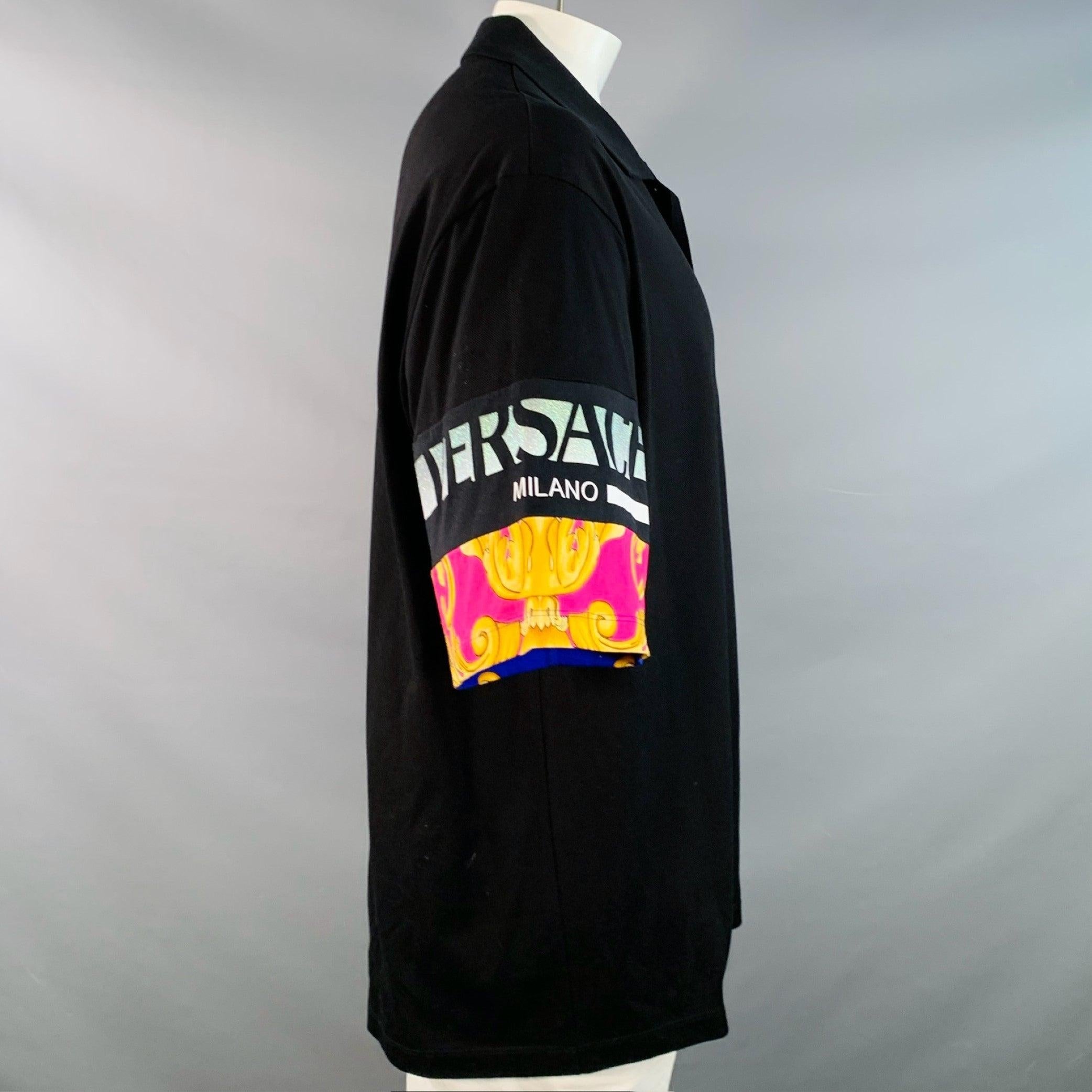 Polo VERSACE
en piqué de algodón negro, con logotipo brillante en las mangas y detalles barrocos en tonos rosas y dorados, corte universitario y media tapeta abotonada. Made in Italy. Muy buen estado de conservación. Pequeñas marcas y signos de
