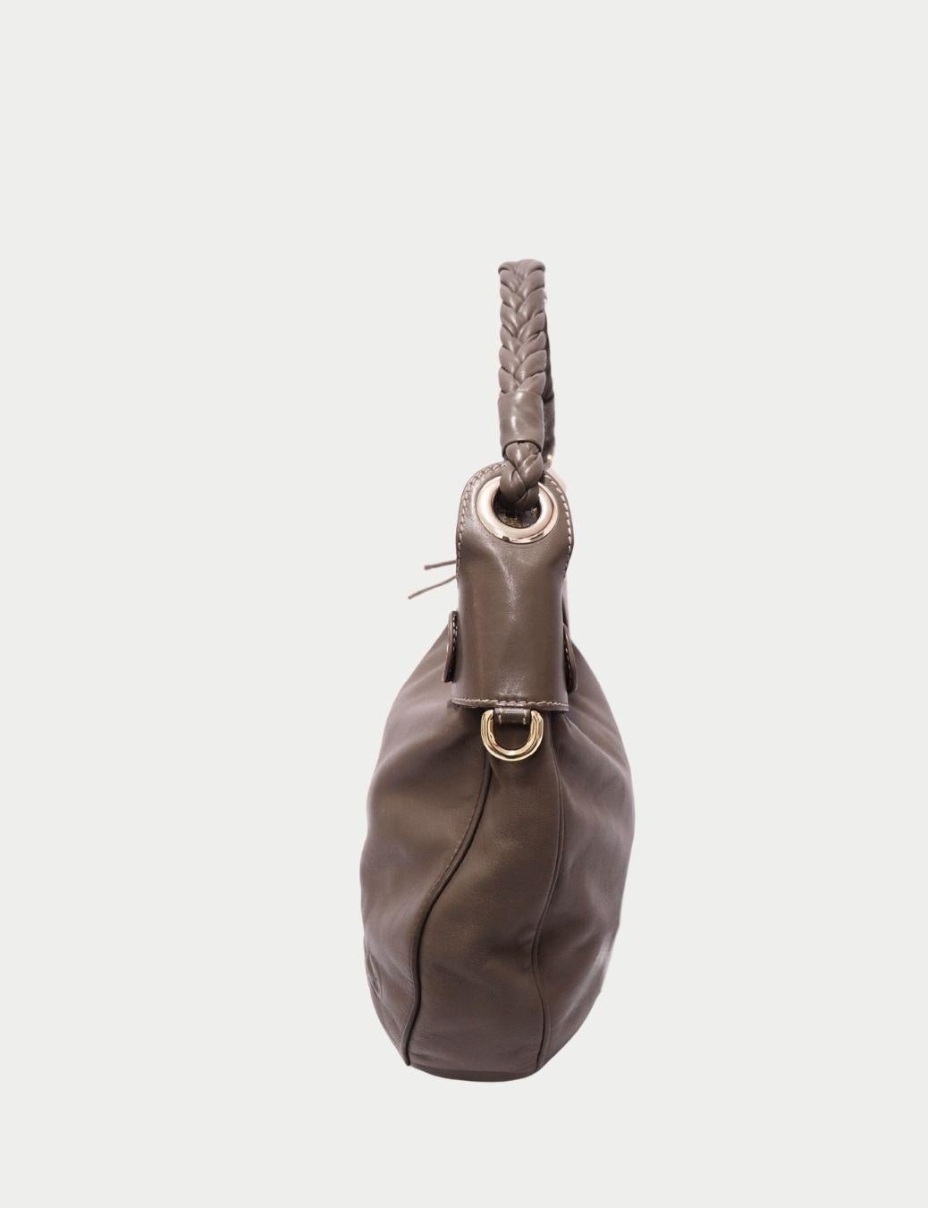 Sac à bandoulière en cuir taupe de Versace - L'élégance iconique de la Méduse

Ajoutez une touche de luxe italien intemporel à votre look de tous les jours avec ce sac à bandoulière en cuir Taupe de Versace. Confectionné en Italie en cuir véritable