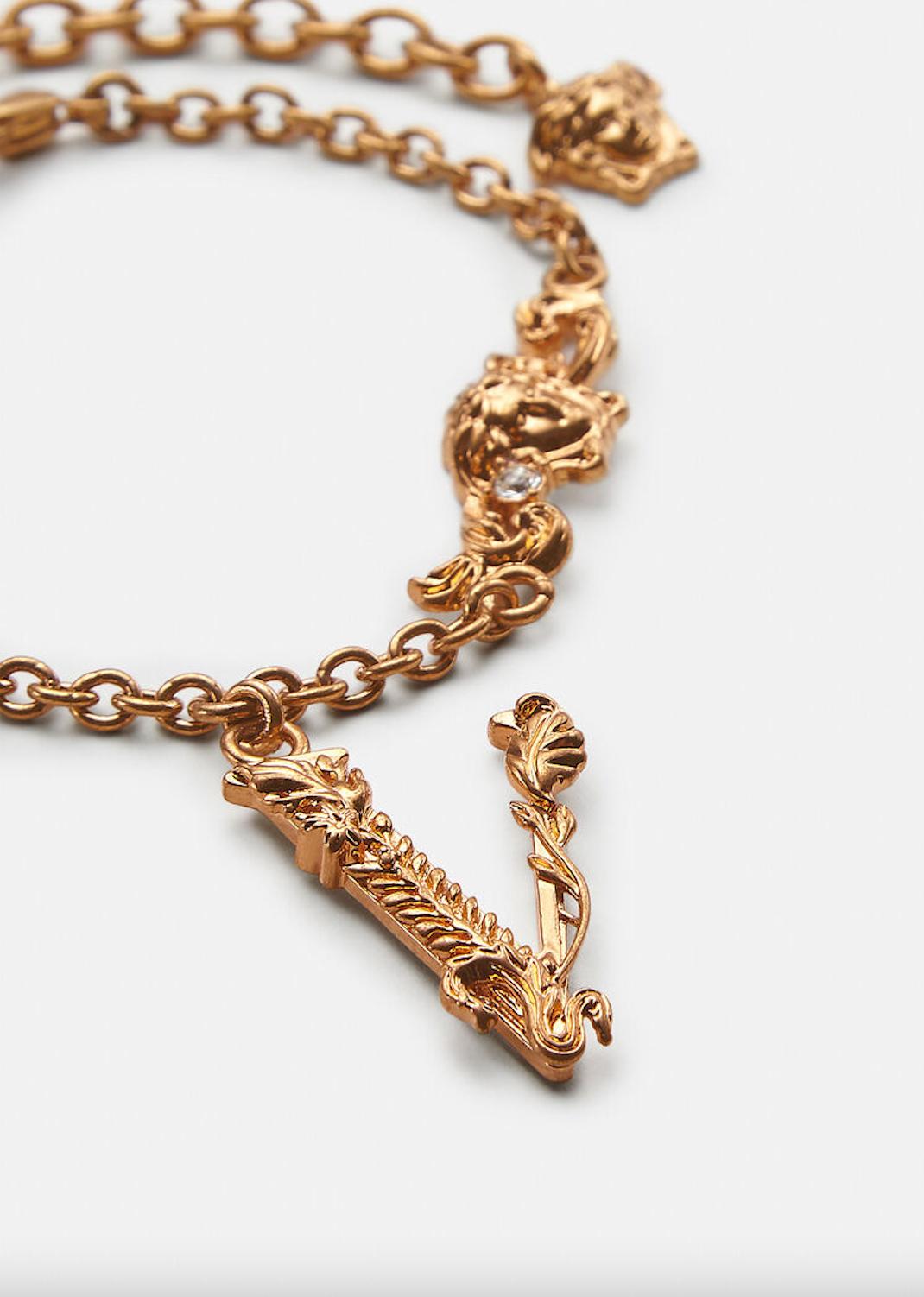 Gold tone bracelet with a Medusa accent and a lobster clasp closure. A bold symbol of the brand’s aesthetic heritage, the Barocco letter V pendant is embellished by acanthus leaves taken from Versace’s signature motif. All Versace Jewelry products
