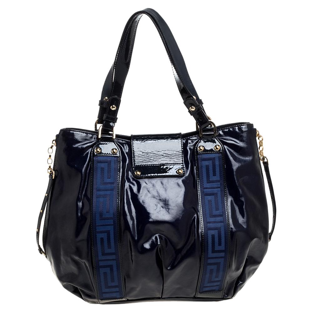 Created from two-tone patent vinyl as well as leather and lined with satin, this Versace bag is a fine accessory for all your needs. The tote has a flap to secure the satin interior, and two shoulder handles for you to parade the beauty. It is
