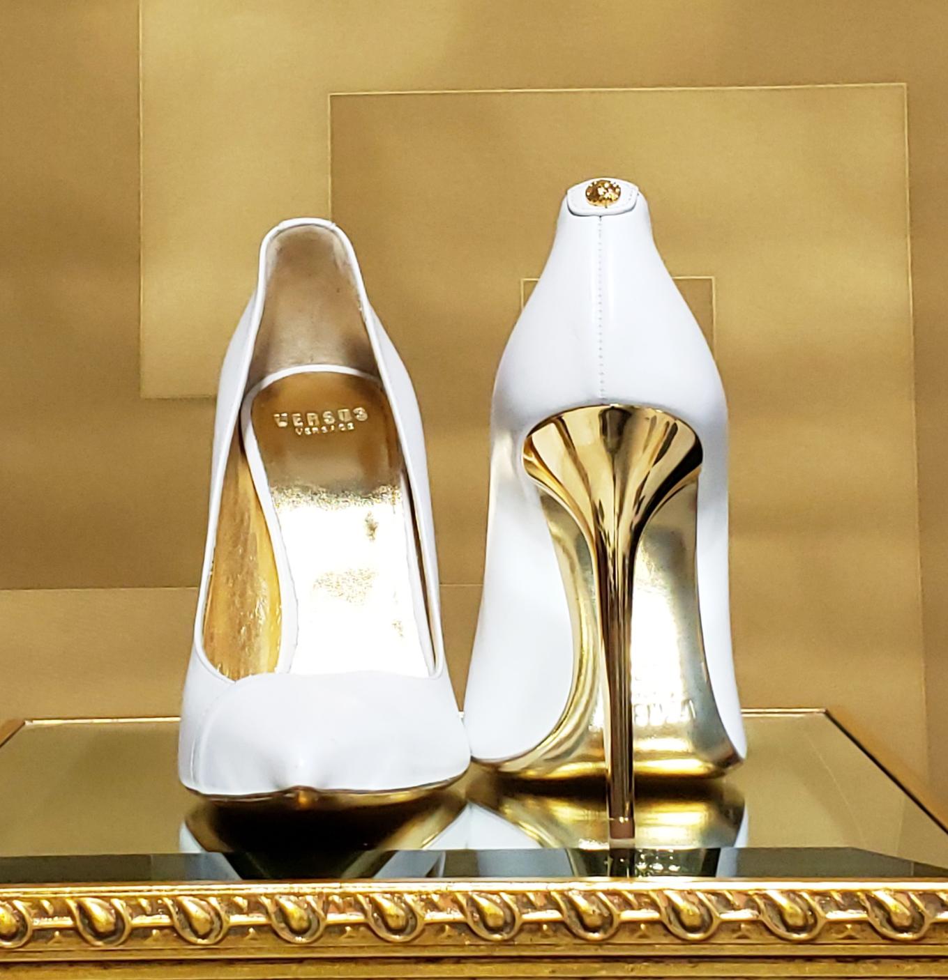 VERSACE VERSUS 
+ Anthony Vaccarello 

PUMPS

White smooth leather Versace pumps with a sexy, pointed-toe profile and gold stiletto heel. 

Gold Lion medallion 


Gold Leather sole.

Made in Italy.

IT Size 39 - US 9

PR Sample. New, in the box. A