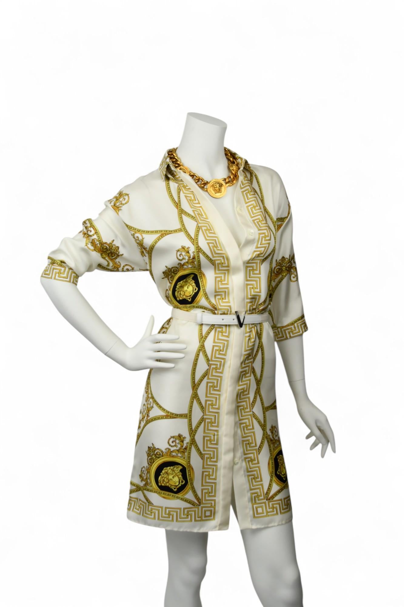 L'opulence s'allie à la précision dans cette robe classique en soie de Versace, ornée des motifs baroques emblématiques de la maison et de bordures en grec dans de riches tons dorés. La silhouette de la chemise de tailleur est rehaussée d'un bouton
