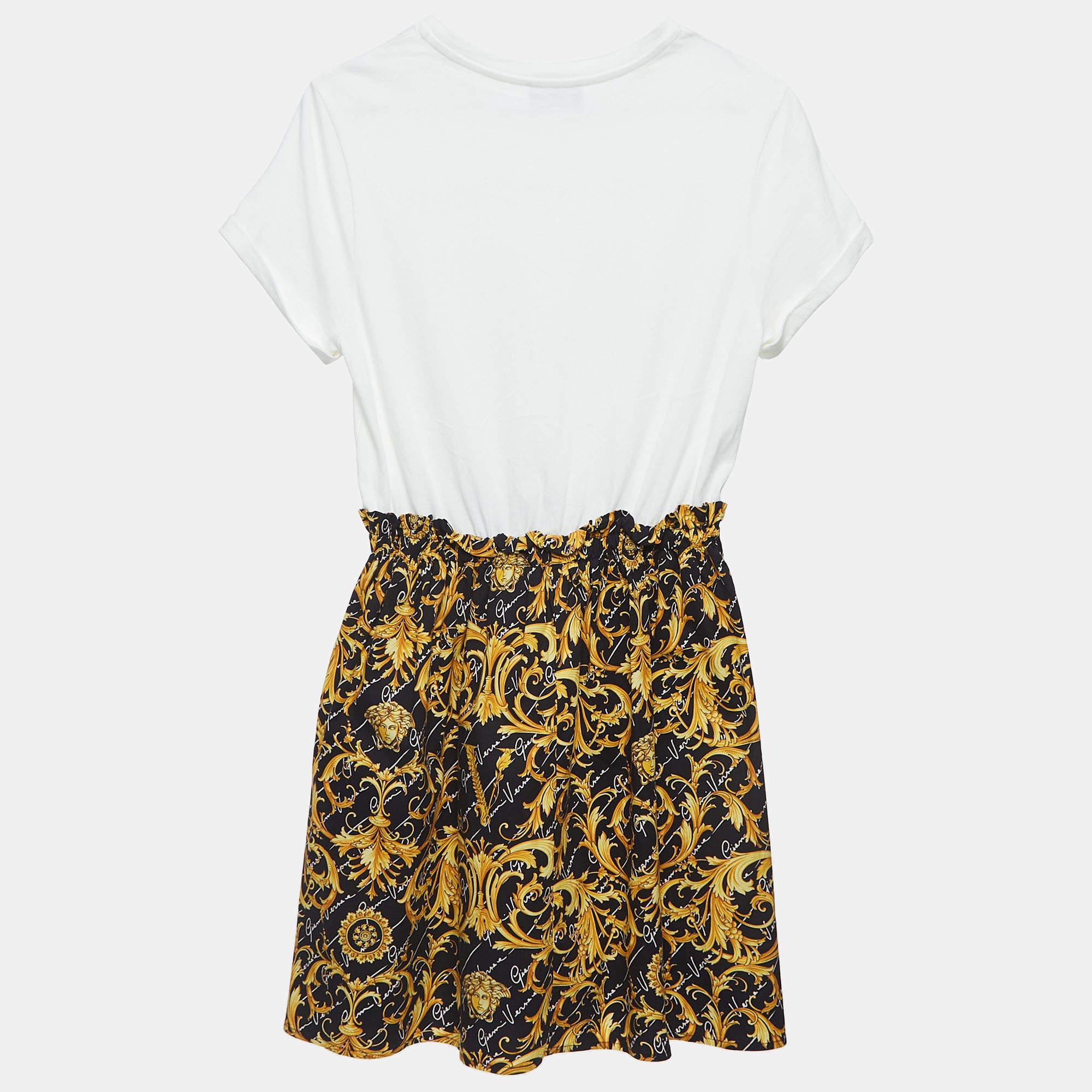 The Versace t shirt dress for kids exudes luxury with its iconic Baroque pattern. Crafted from premium cotton this miniaturized masterpiece features a monochromatic palette delivering a stylish blend of comfort and high end fashion for the young