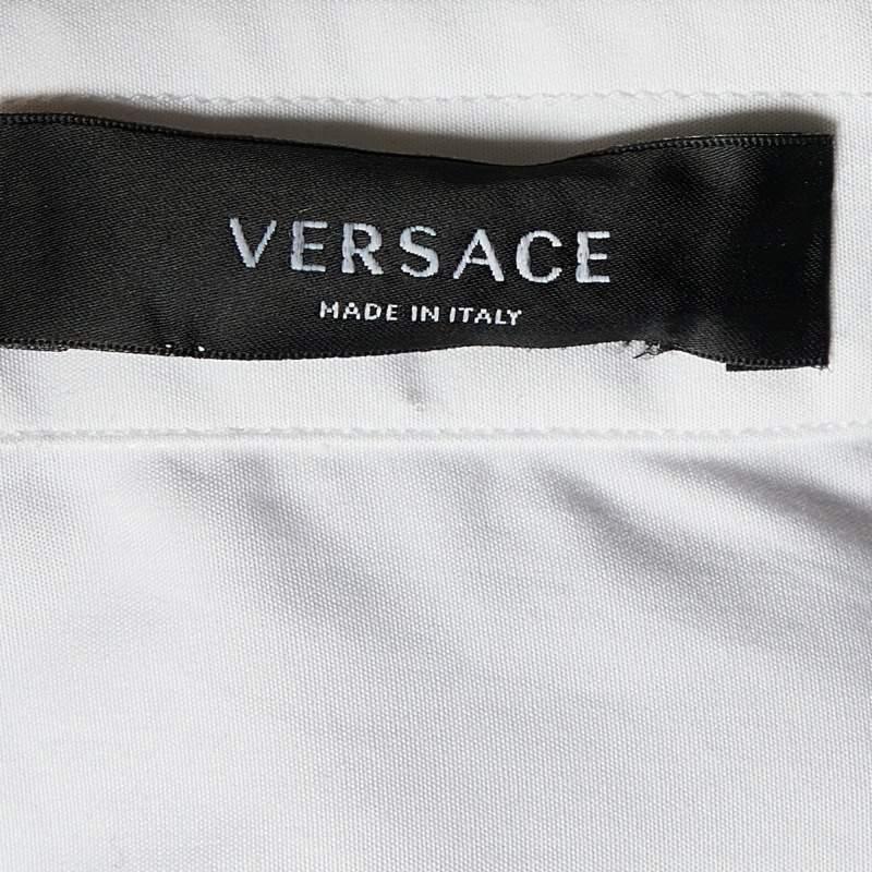 Elevate your wardrobe with the exquisite Versace shirt. Impeccably crafted from premium cotton, this shirt exudes sophistication and refinement. The intricate crystal buttons detailing adds a touch of opulence, ensuring you stand out with