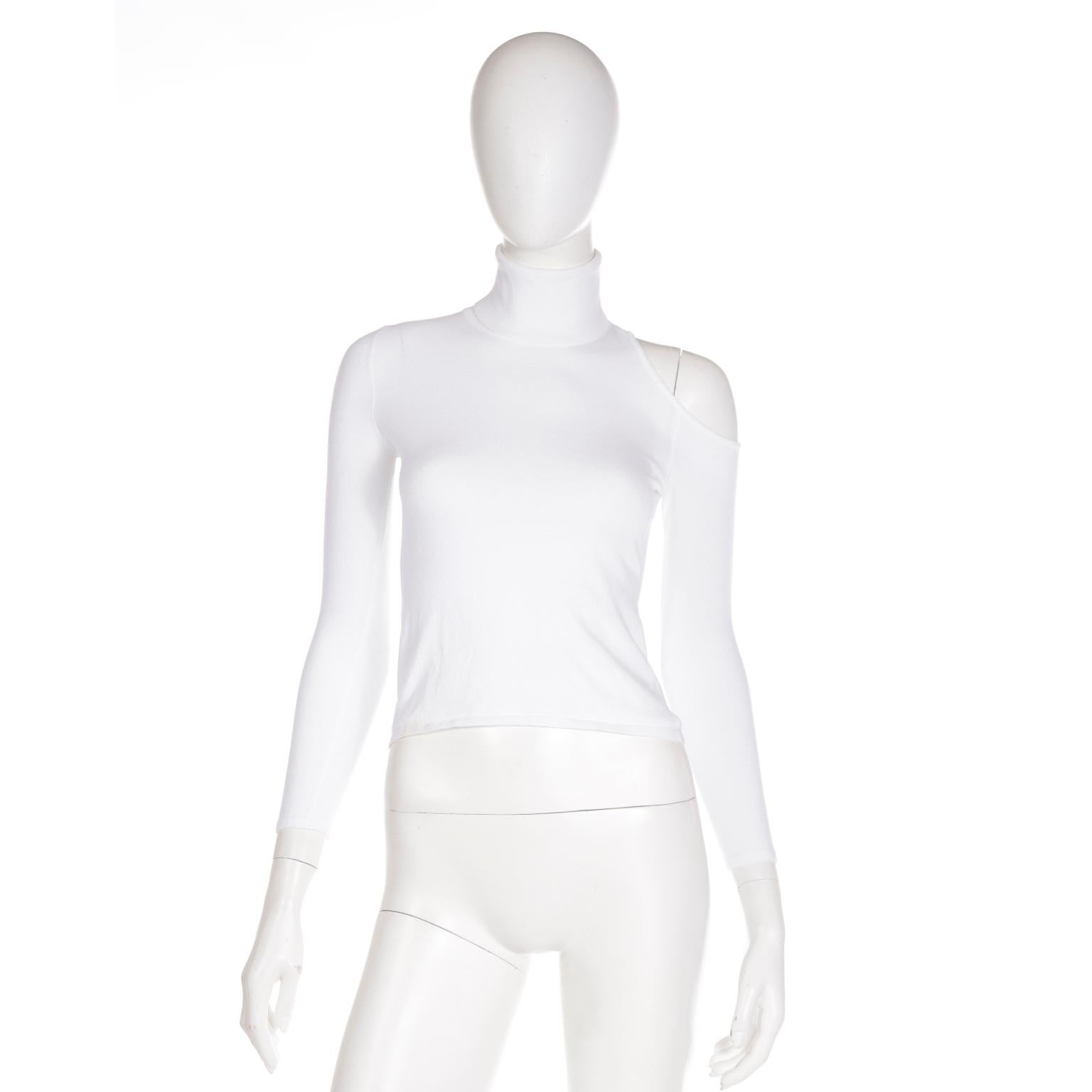 This fun Versace white turtleneck top has a unique cut out on one of the shoulders that extends to the back. This top would be a great staple for any Summer wardrobe and it can be worn with a variety of things you already own! The top is in a soft