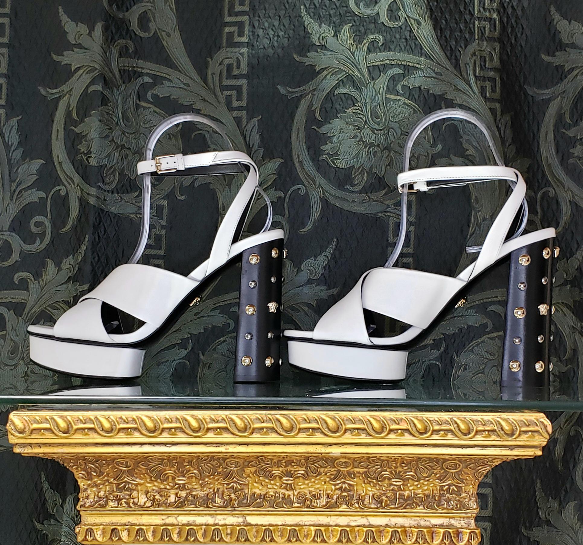 VERSACE

White leather sandals shoes with gold and silver studs and famous Medusa Studs

DETAILS:

Open toe and heel

Buckling ankle strap closure

Content: 100% Leather (Lining and Sole) 


   Color: White

Heel: 5 1/8 inches

Platform: 1 inch
