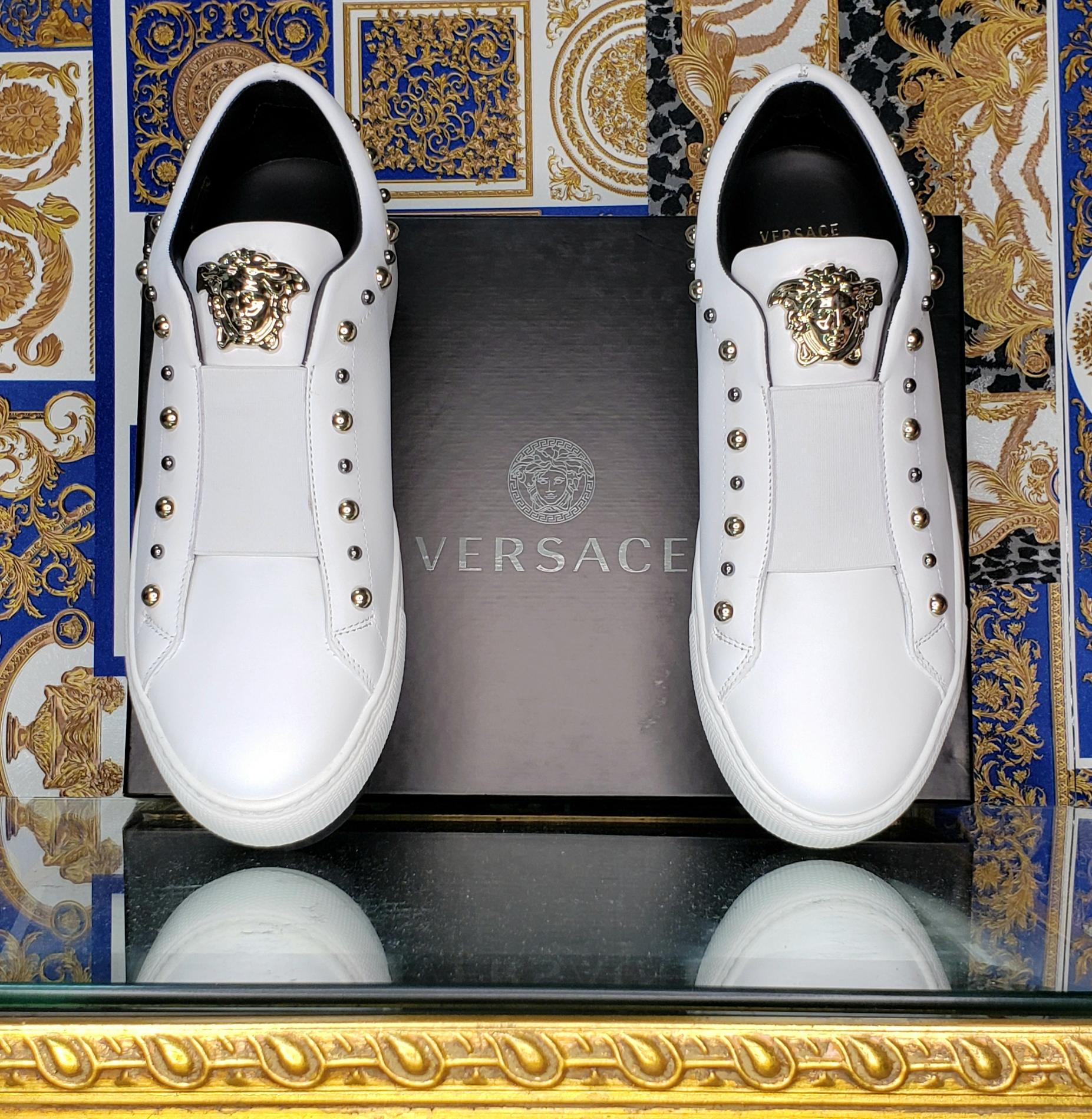 VERSACE 

White leather sneakers
Gold-tone 3D Medusa

Gold and silver-tone studs

High Rubber sole

Content: 100% Leather 

   Color: White


The thickness of the sole approximately 2