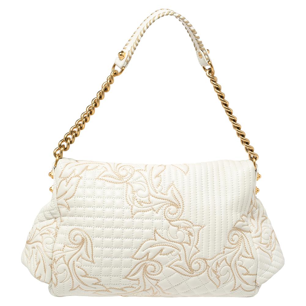 This Versace Barocco bag delights not only with its appeal but craftsmanship as well. It is held by a single handle, adorned with lovely embroidery all over, and equipped with a spacious canvas interior. The unique shape, the notable Medusa logo in