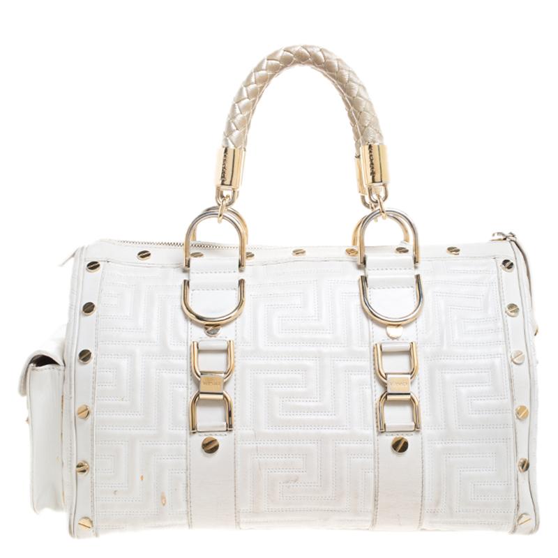 How gorgeous is this satchel from Versace! It carries an outstanding design and a fabulous interplay of white leather and gold-tone hardware. It has a top leading to a satin interior while being held by two top handles. The shape and the brand logo