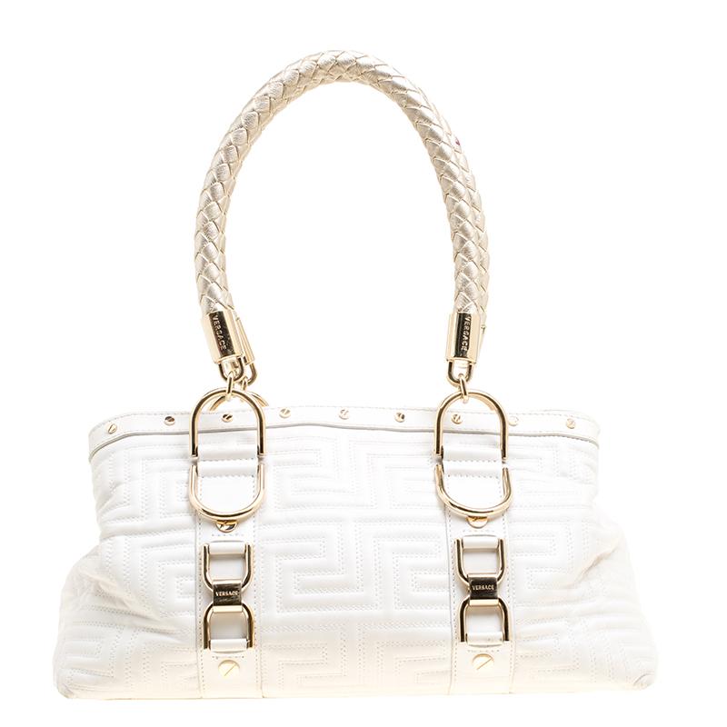 This bold and eye-catching Versace Snap Out Of it satchel is sure to make heads turn. Crafted from white quilted leather the bag is accented with a Gianni Versace Couture plate and gold-tone studded hardware. It features dual top braided handles and