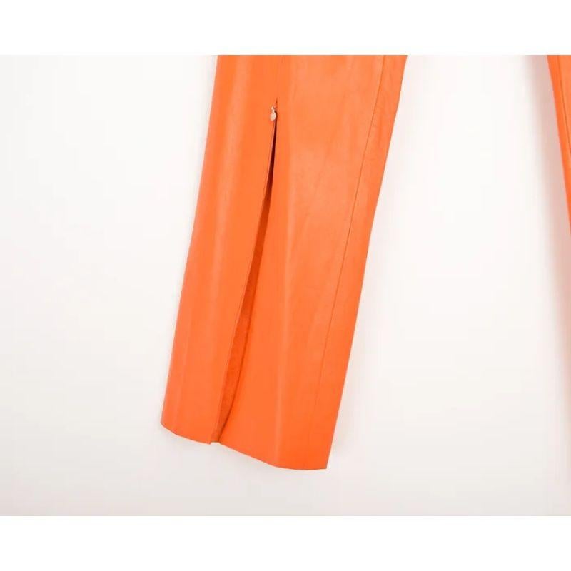 Pantalon en cuir de Versace Jeans Couture du début des années 2000, de taille moyenne (juste en dessous de la ceinture) et de couleur orange mandarine. 

Caractéristiques :
Coupe mi-haute
Fermeture éclair latérale dissimulée
Fermeture éclair à la