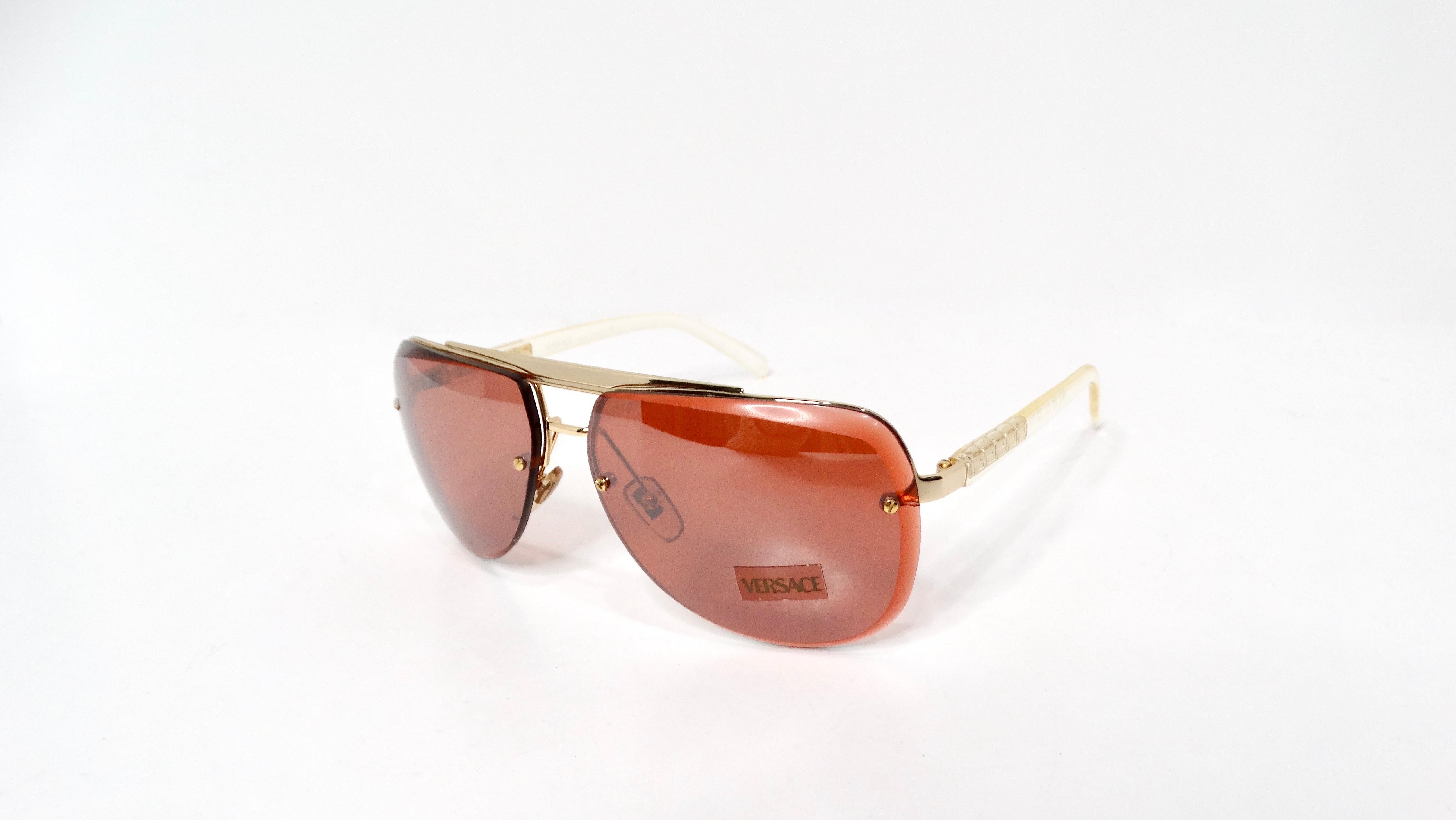 Introducing the Versace Y2K X87 Aviator Sunglasses, a stunning blend of bold fashion and distinctive craftsmanship. Featuring a striking burnt orange tinted lens, these sunglasses are perfectly accented by intricate gold-tone frames that exude