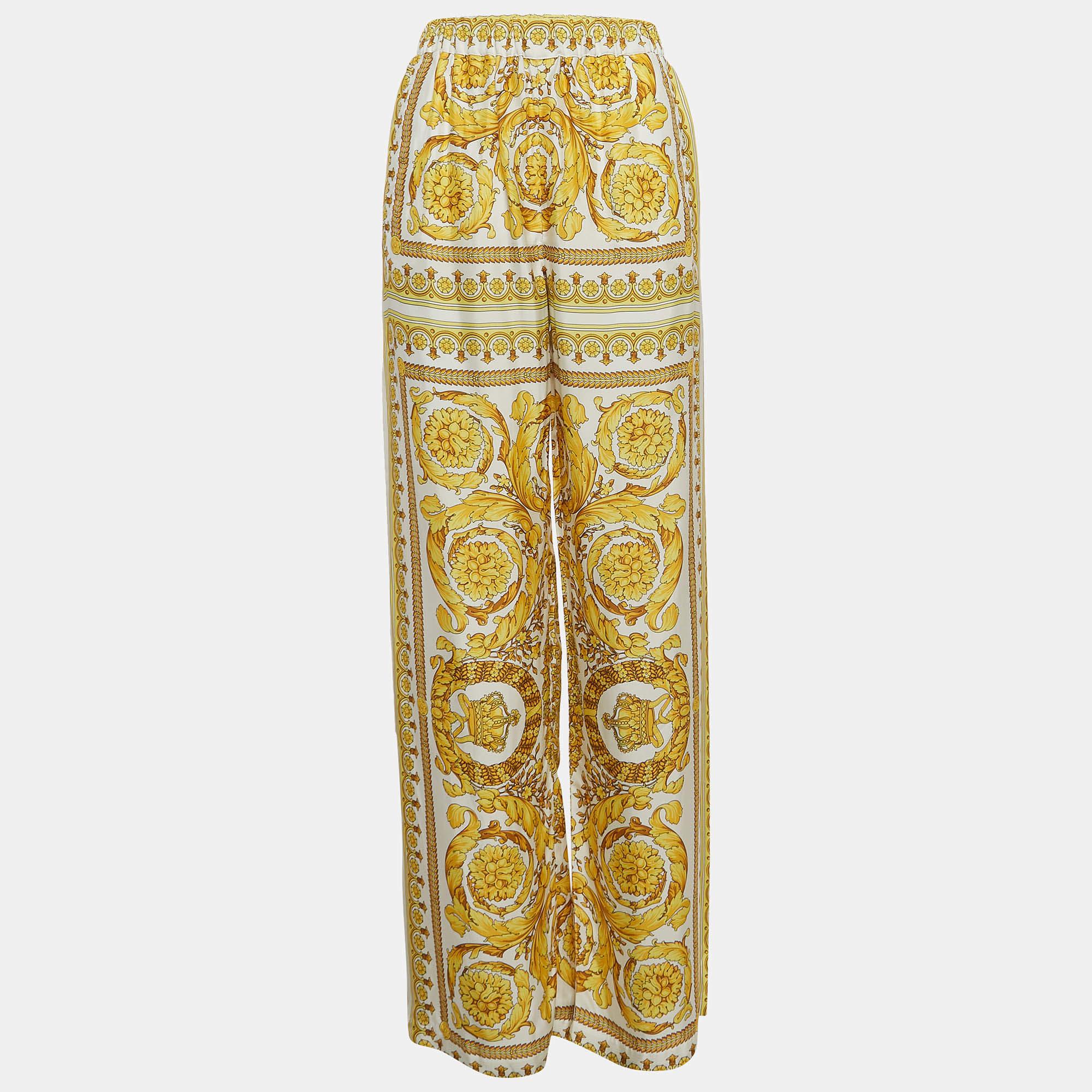 The Versace trousers epitomize luxury and elegance. Crafted from premium crepe fabric, these trousers feature the iconic Barocco print in vibrant yellow hues, exuding sophistication. With a flattering wide-leg silhouette, they effortlessly merge