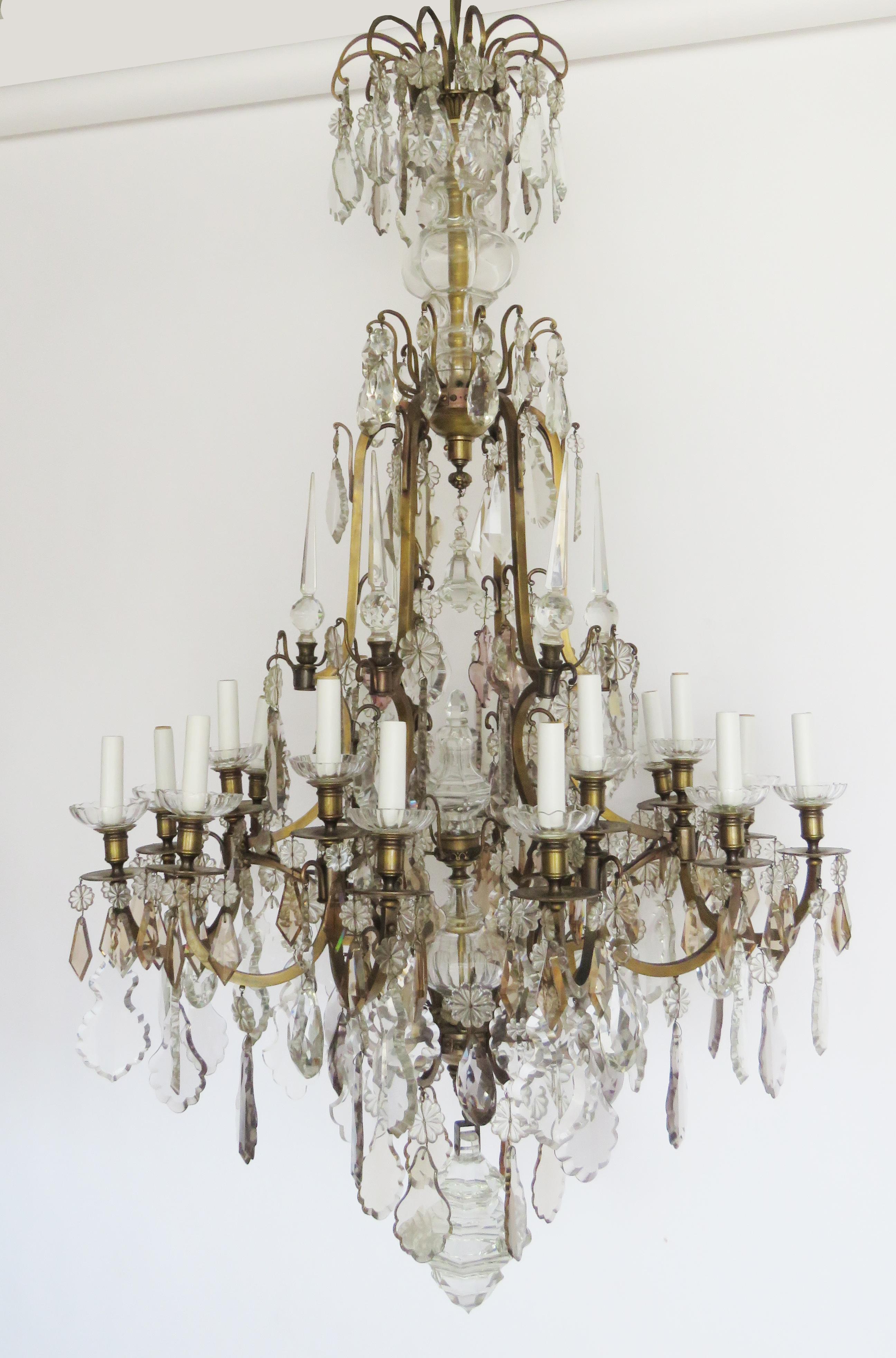 Impressive Versailles chandelier with crystal column, fine gilt arms and 21 candle arm lights with glass bobeches supporting colored crystal prisms and rosette pendants. UL wired.