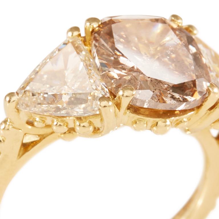 Exquisite ring with centre cushion cut cinnamon diamond 3 carat with shoulders trillion cut champagne diamonds 1 carat each, set in 18 carat yellow gold. Ring available in size M1/2. 

Esther Eyre has been designing and making precious jewellery for