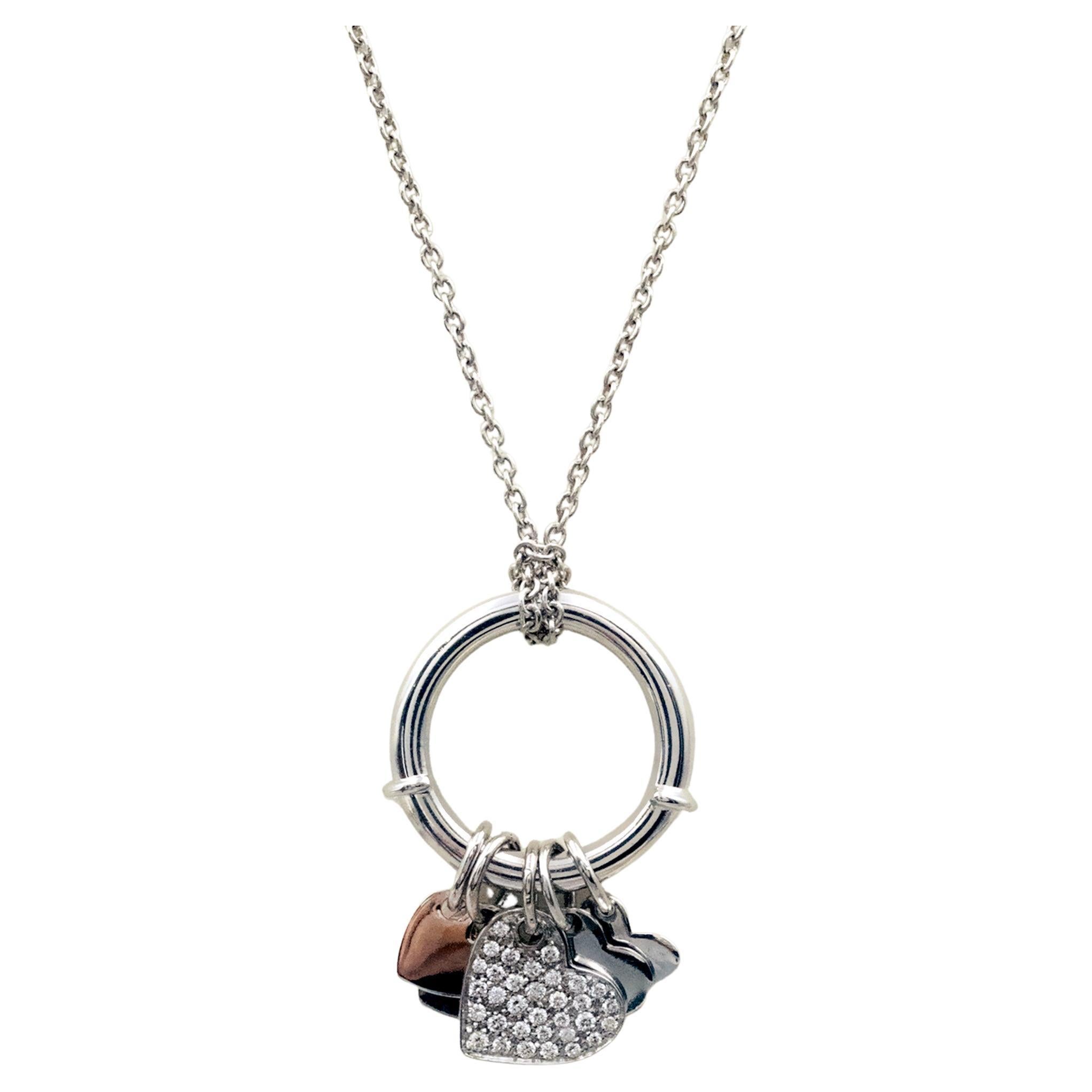 This lovely modern 18K white gold charm Pendent and ring is a true statement of elegance and versatility. Designed with a contemporary yet timeless aesthetic, it features a collection of heart-shaped charms, including a dazzling pavé-set diamond