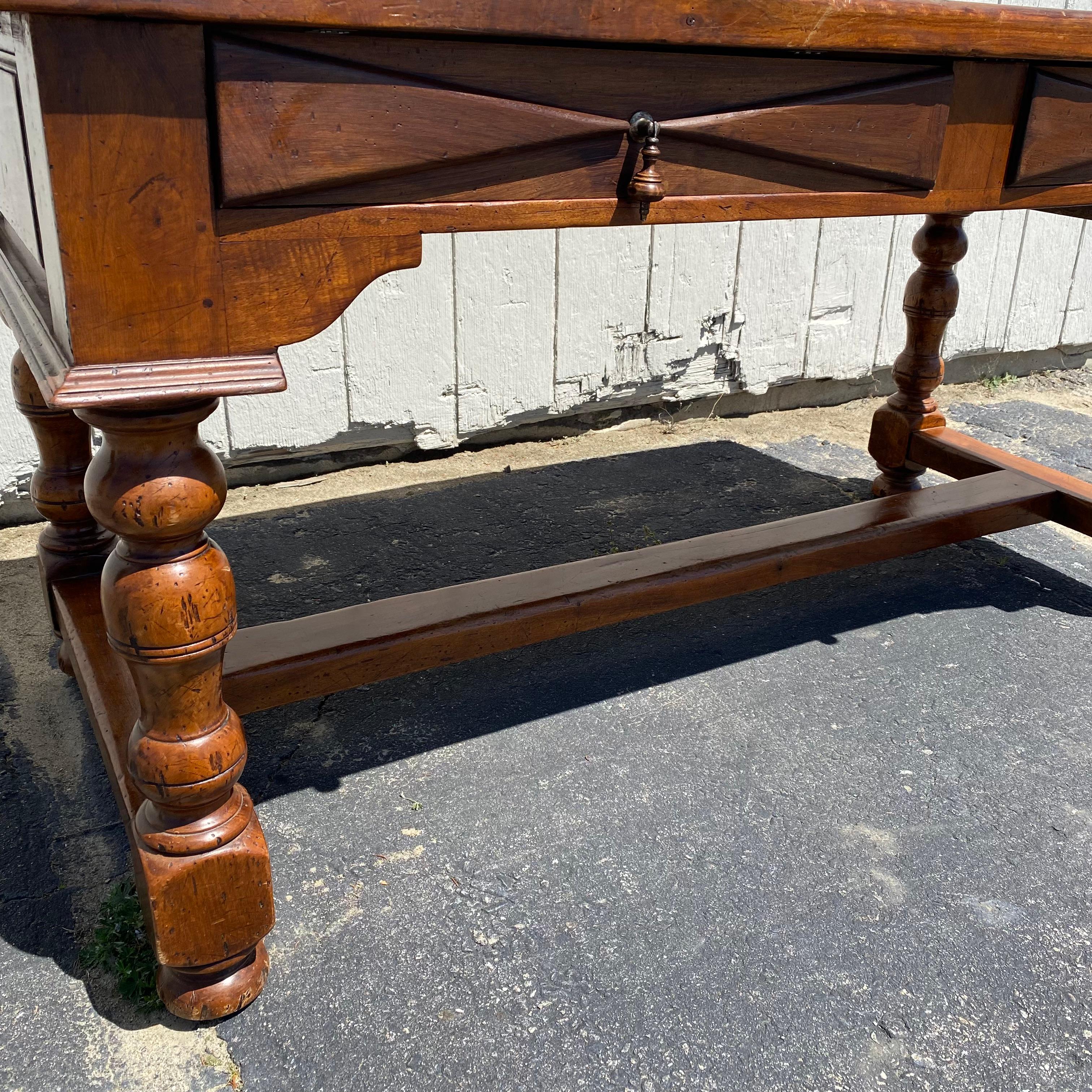 Found in the South of France, this 19th French hand carved walnut table or desk may be placed in the middle of a room as it is beautifully carved on all sides. It features a beautiful solid wooden top in a buttery camel color, over two sizeable