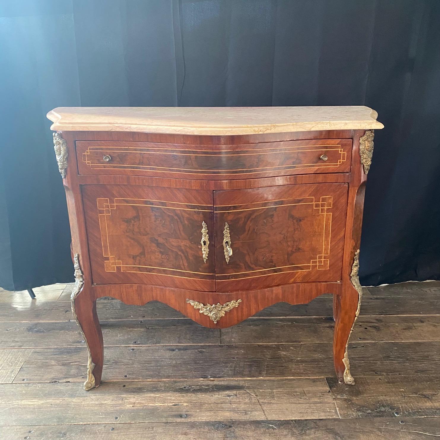 Versatile Louis XV small chest with one drawer and two doors, all inlaid with beautiful marquetry and ormolu mounts. Carrara marble top is shaped and beveled.
#2930.
 

 