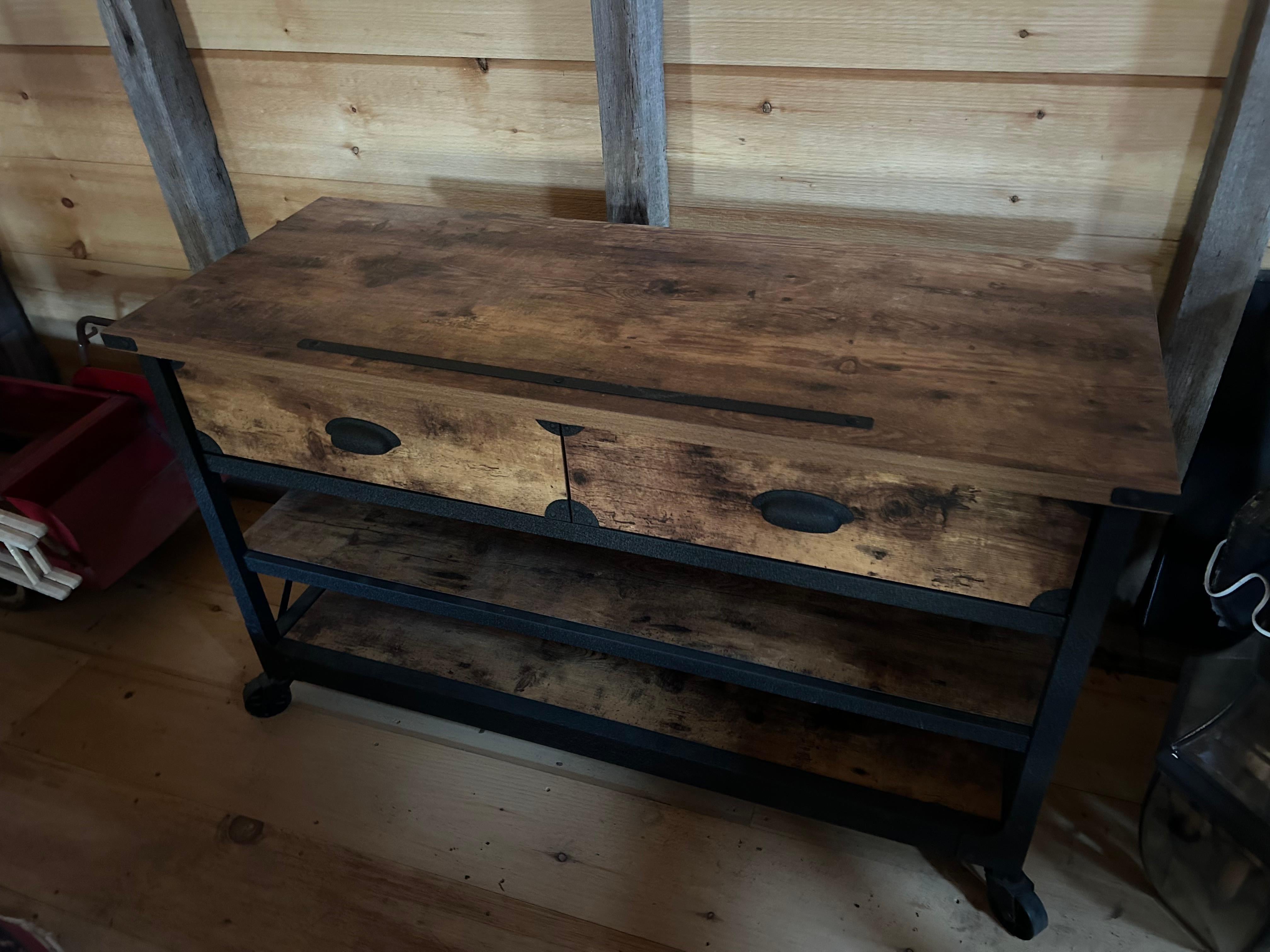Handsome industrial console made of black iron and reclaimed wood having two drawers, two lower shelves, black casters, and many versatile uses.  Great in a kitchen!  
Lower shelf 6” from the floor. Middle shelf 13.5 from floor