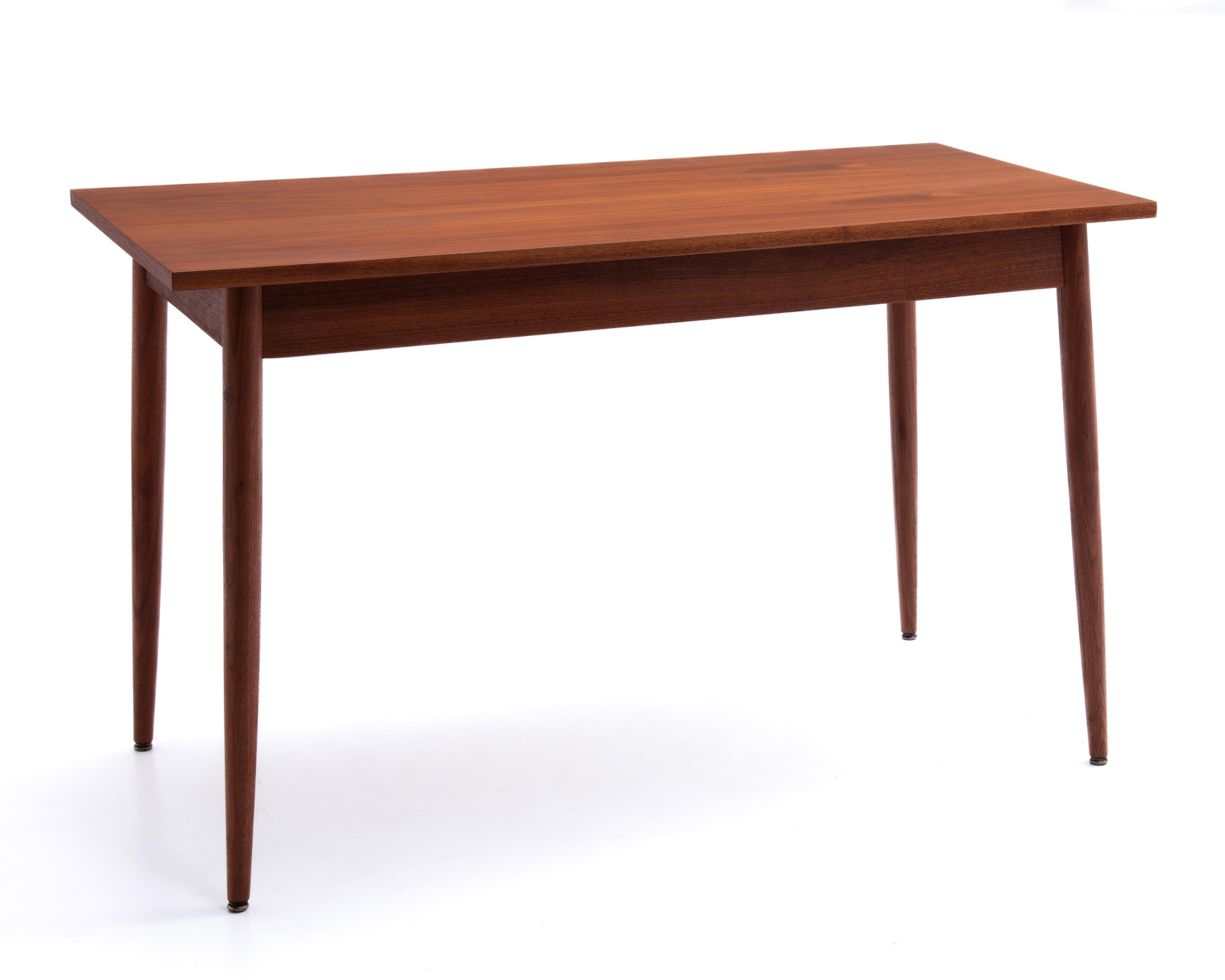 Une table de cuisine, de salle à manger ou un bureau polyvalent en noyer du milieu du siècle. Plateau assorti à un livre et pieds solides. Le plateau et les pieds sont en superbe état et semblent presque neufs. Le dessous et les ferrures confirment