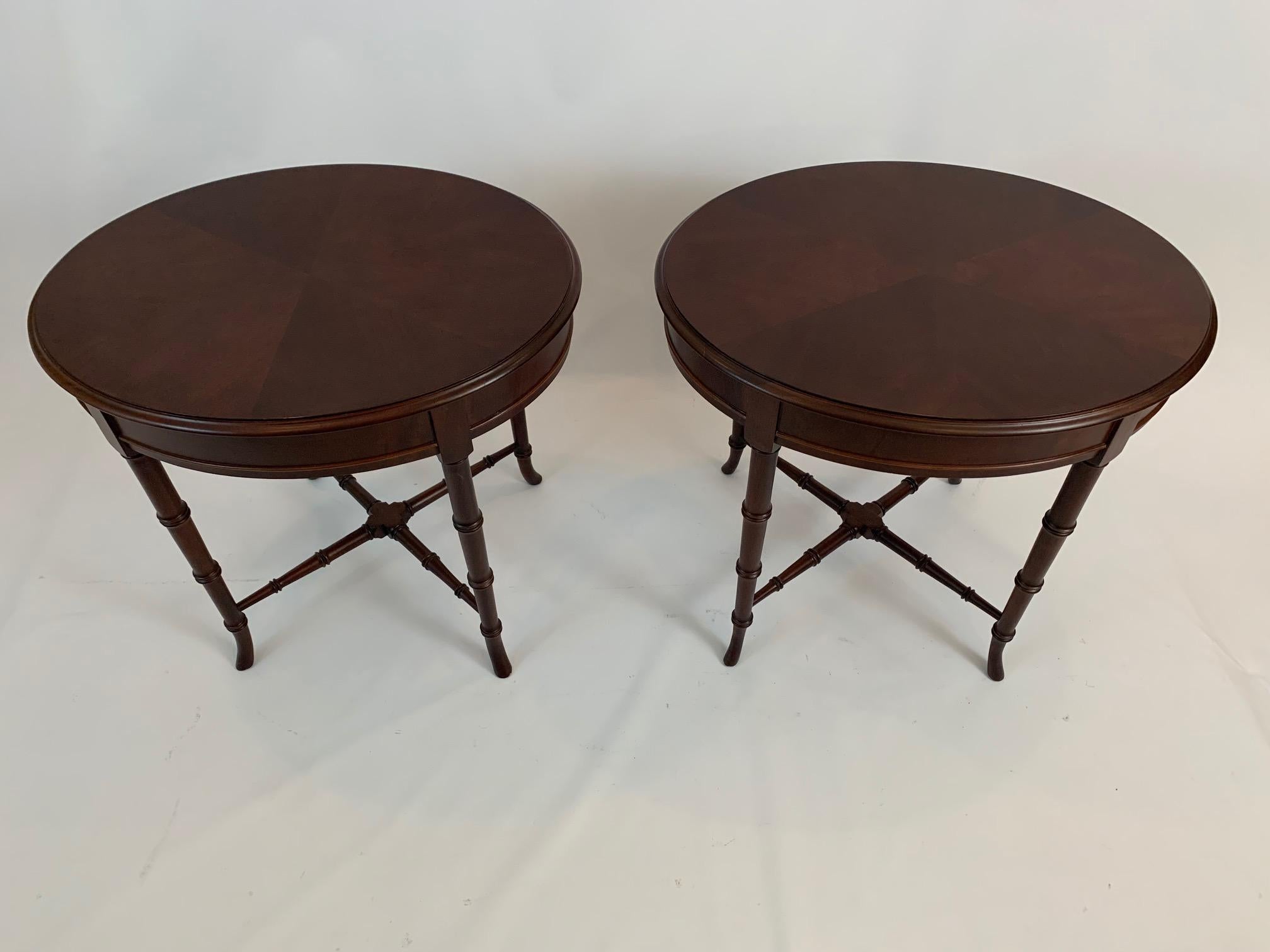 Refined and versatile pair of mahogany oval end tables having faux bamboo legs and stretcher.
Top has a beautiful star/flower design.
 