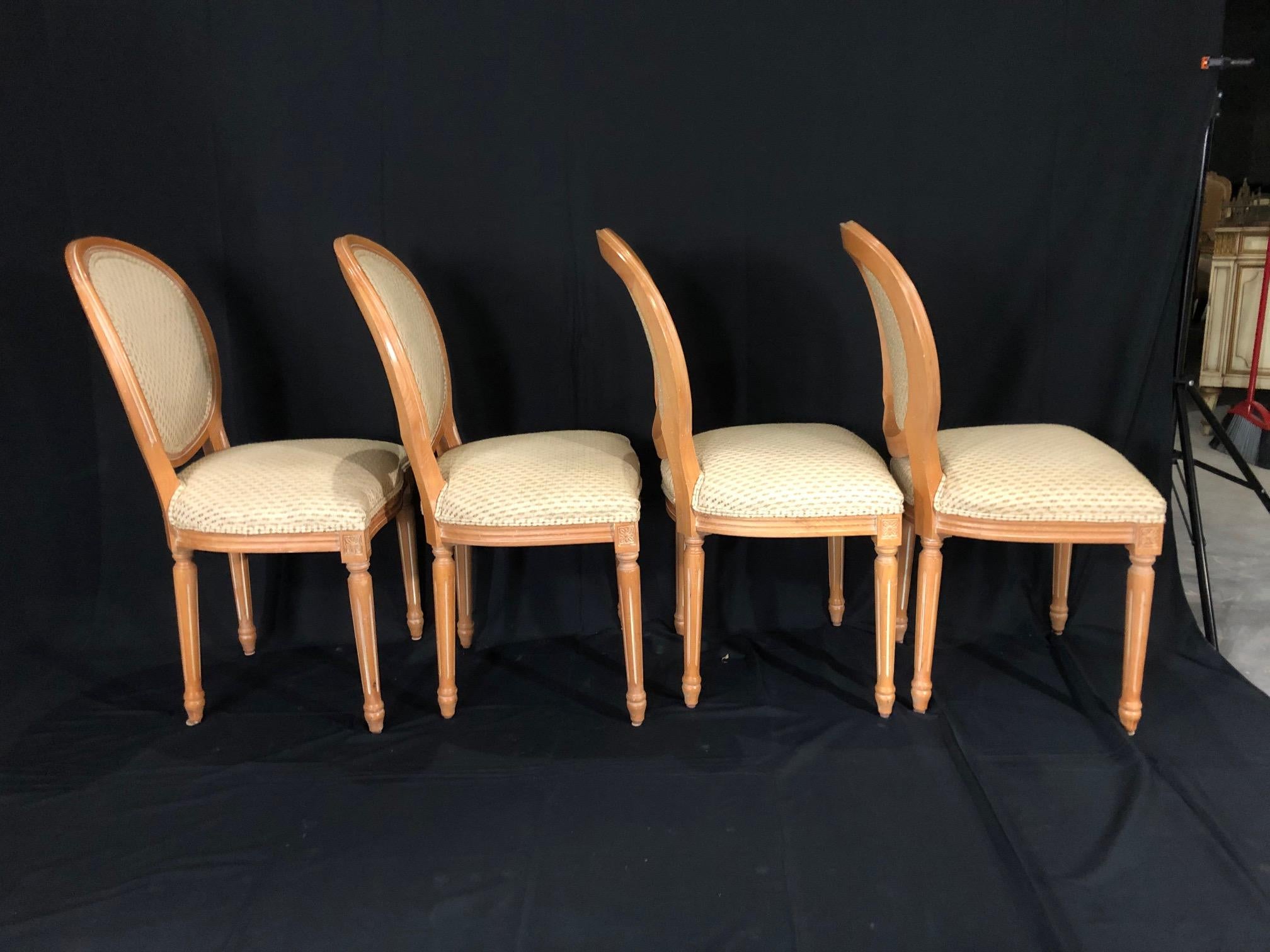 A set of 4 custom Louis XVI style carved wood dining chairs upholstered in lovely neutral ivory material with beige flecks.