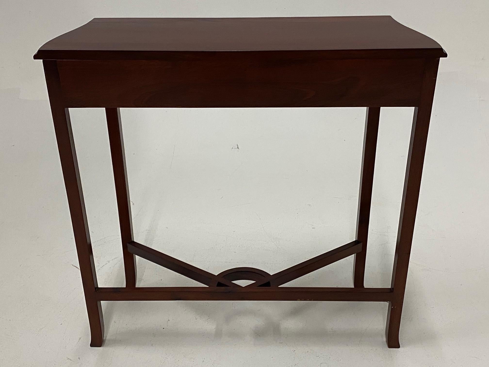 A cute sized mahogany console having lovely fret work apron on front and sides and a nicely designed stretcher beneath.