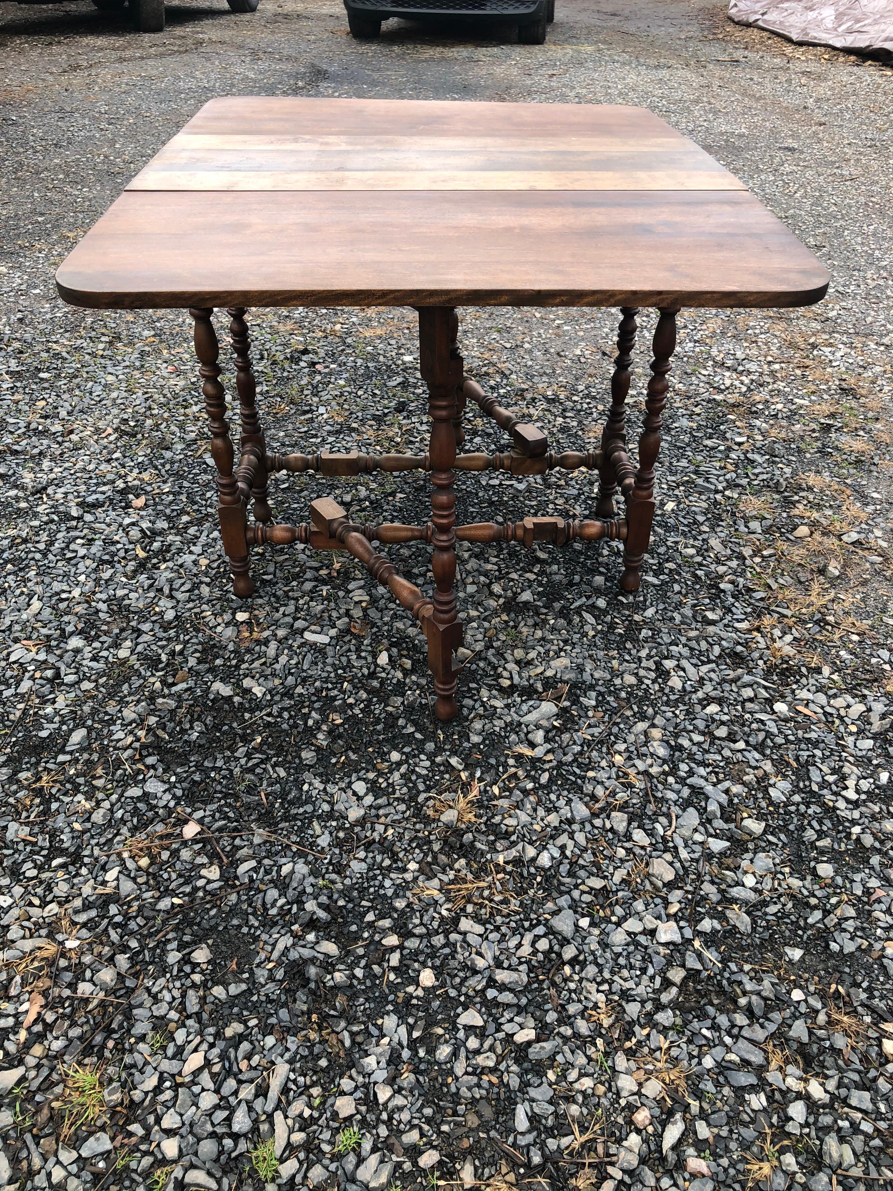 Versatile drop leaf mixed wood table having turned legs.  When open 48