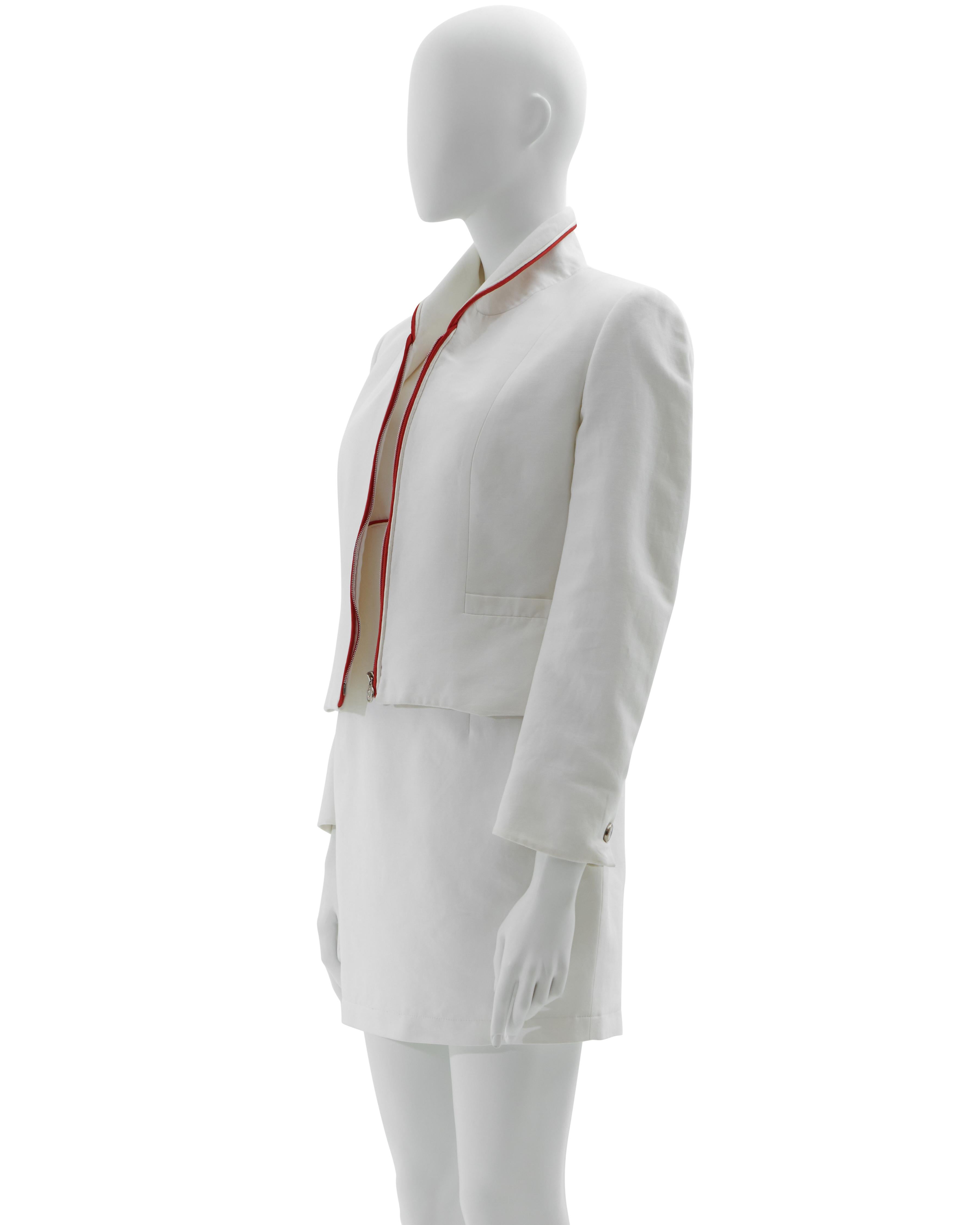 - Anfang der 1990er Jahre 
- Verkauft von Skof.Archive
- Entworfen von Gianni Versace
- Versus von Gianni Versace
- Weißer Baumwollstoff mit rotem Profil - Jacke und Kleid im Set
- Medusa-Reißverschluss an der Vorderseite der Jacke
- Kleid mit