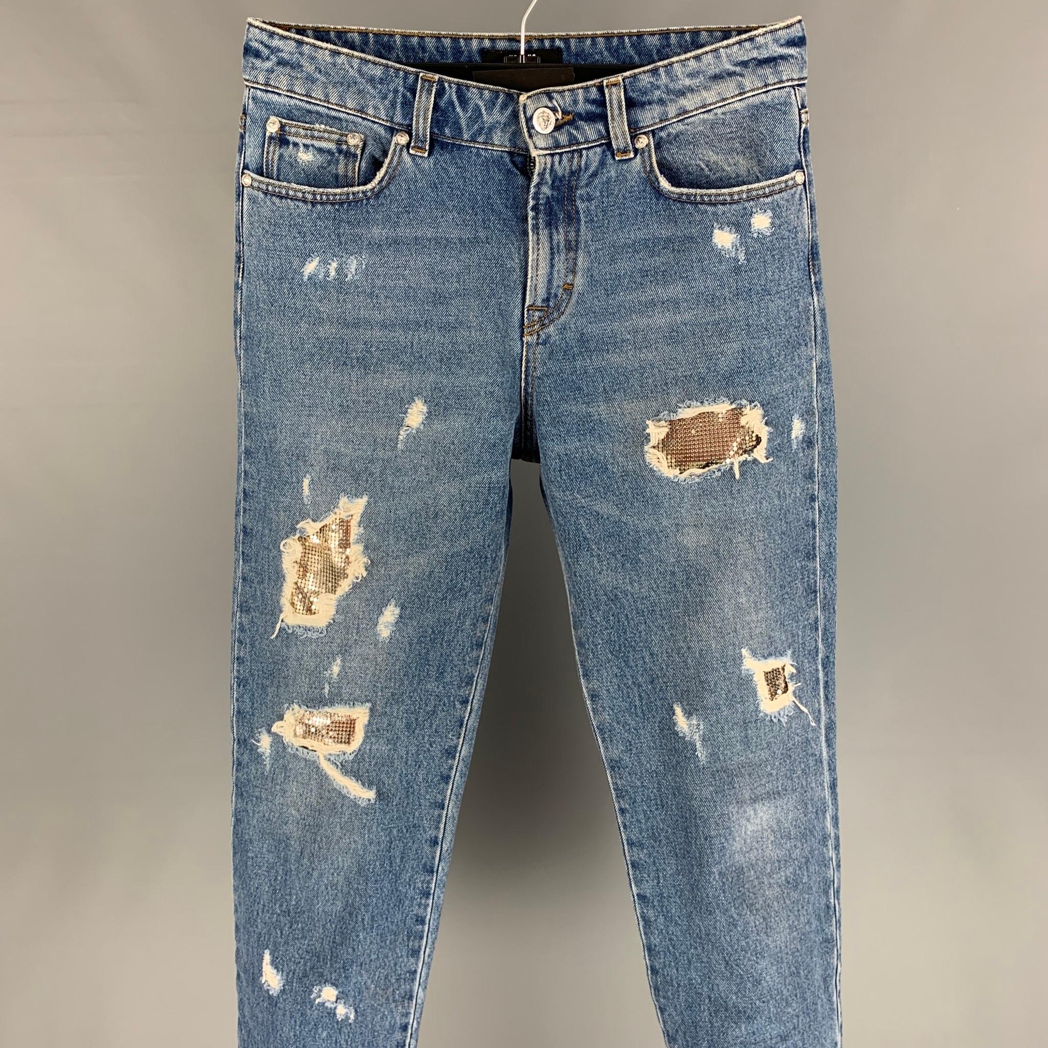 VERSUS by GIANNI VERSACE jeans comes in a indigo distressed denim featuring a underlay metal design, contrast stitching, silver tone buttons, and a zip fly closure. Made in Romania. 

Excellent Pre-Owned Condition.
Marked: 27

Measurements:

Waist: