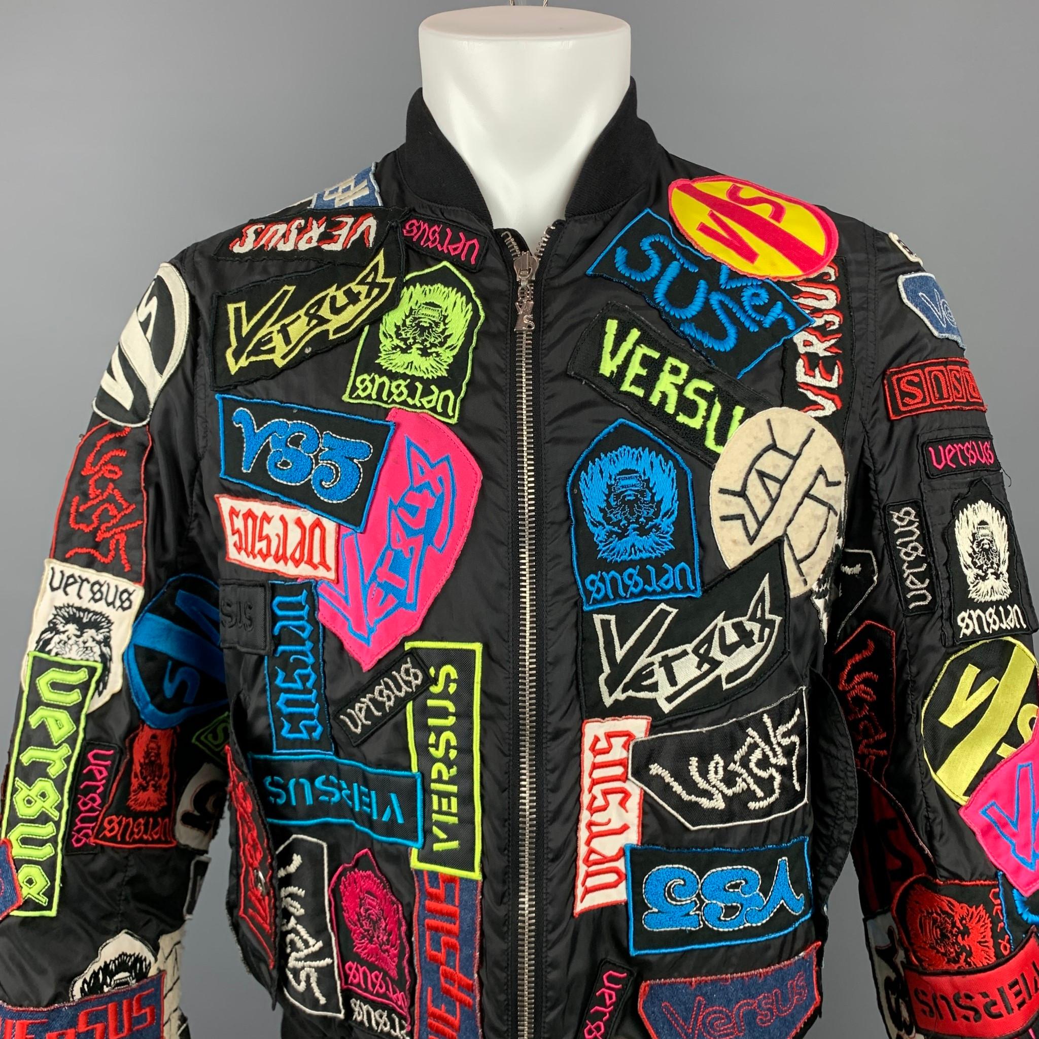 VERSUS by GIANNI VERSACE jacket come in a multi-color nylon with patch details throughout featuring a bomber style, flap pockets, and a full zip up closure. Made in Italy.

Very Good Pre-Owned Condition. Minor wear on patches.
Marked: