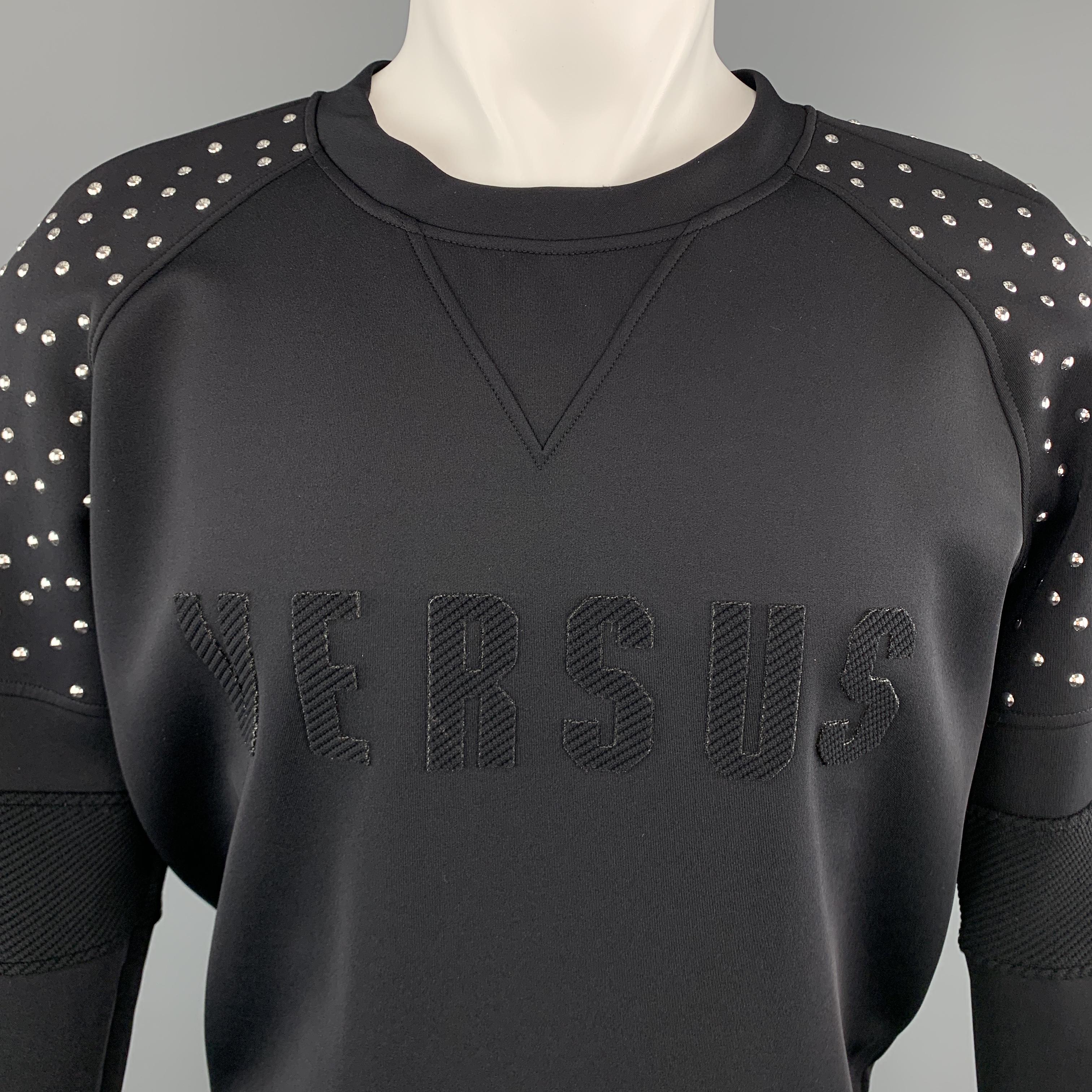 VERSUS by VERSACE pullover comes in a neoprene style knit with a crewneck, textured logo applique, and raglan patchwork sleeves with silver tone studded shoulders. Made in Italy.

Excellent Pre-Owned Condition.
Marked: 38

Measurements:

Shoulder: