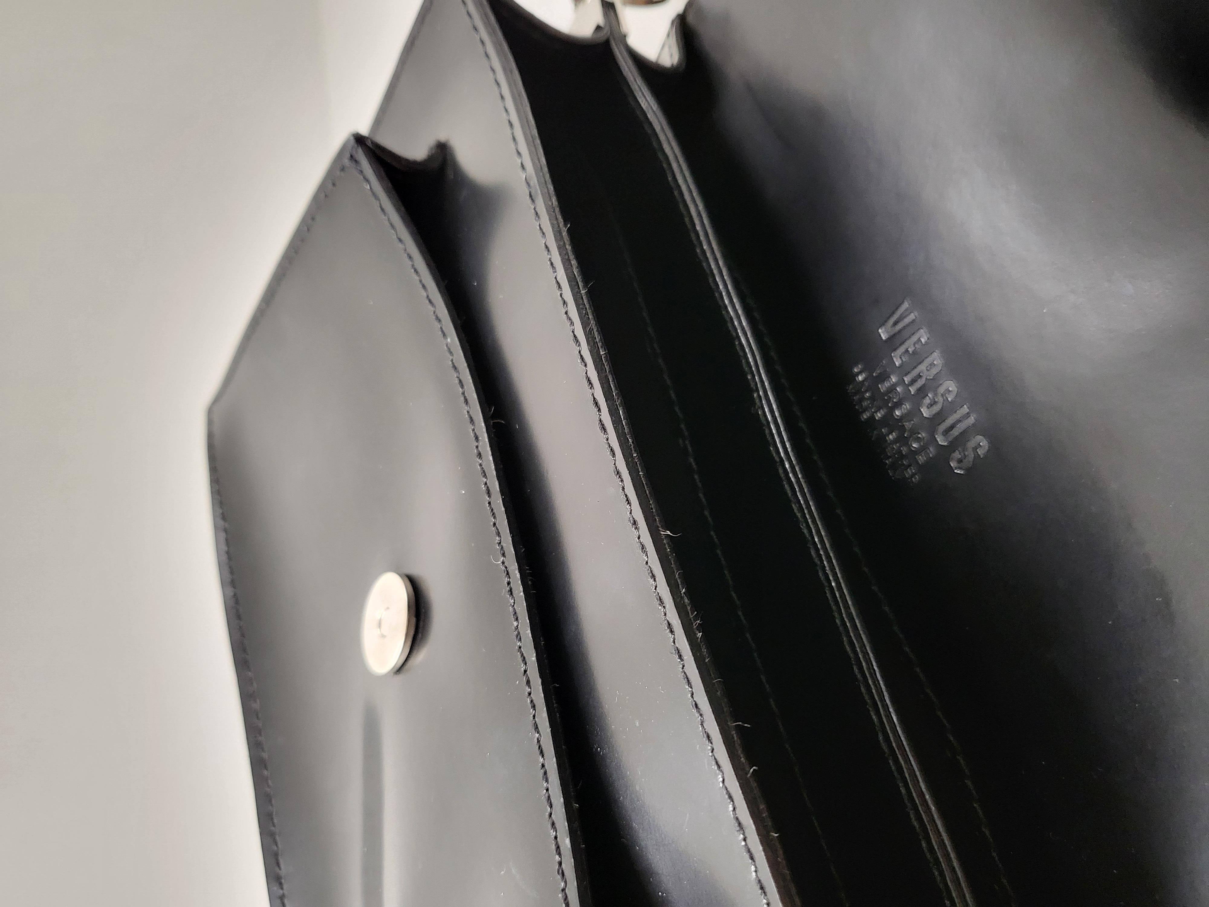 Certainly! Here's a product description for the Versus by Versace Large Silver Buckled Closure Black Leather Sling Shoulder Bag:

---

Step into luxury with the Versus by Versace Large Silver Buckled Closure Black Leather Sling Shoulder Bag, a