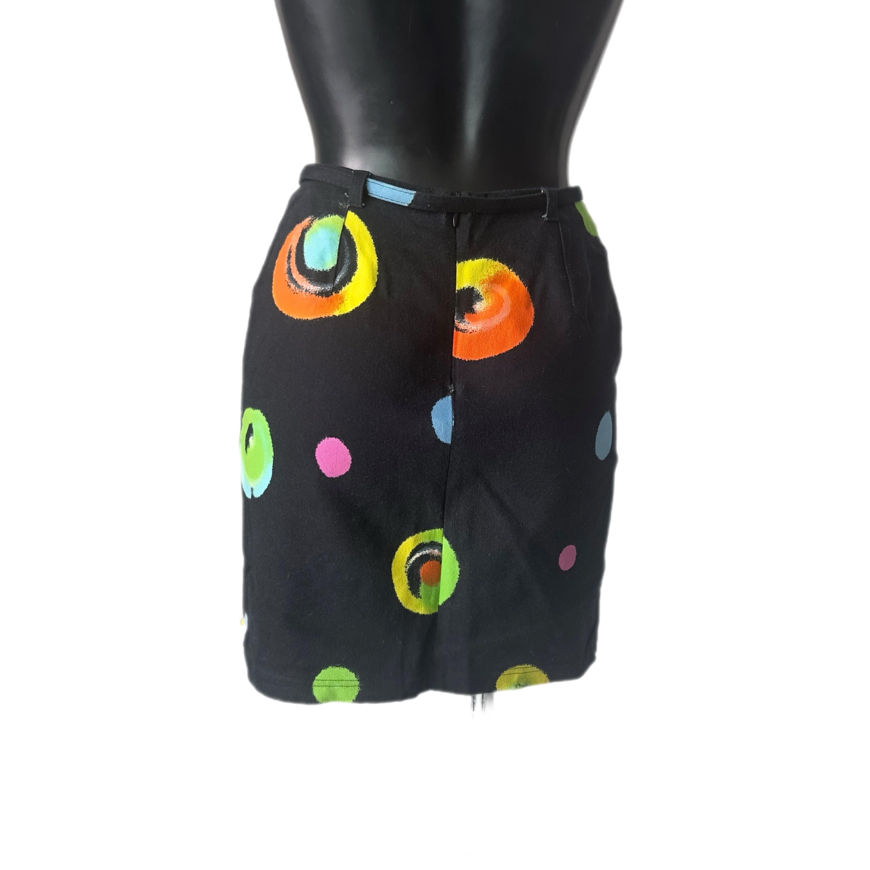 Dieser lebhafte und ikonische Minirock von Versus Gianni Versace ist ein authentisches Beispiel für den kühnen und verspielten Geist der Maison in den 1990er Jahren. Es ist aus schwarzem Stretch-Stoff gefertigt und mit einem mehrfarbigen,