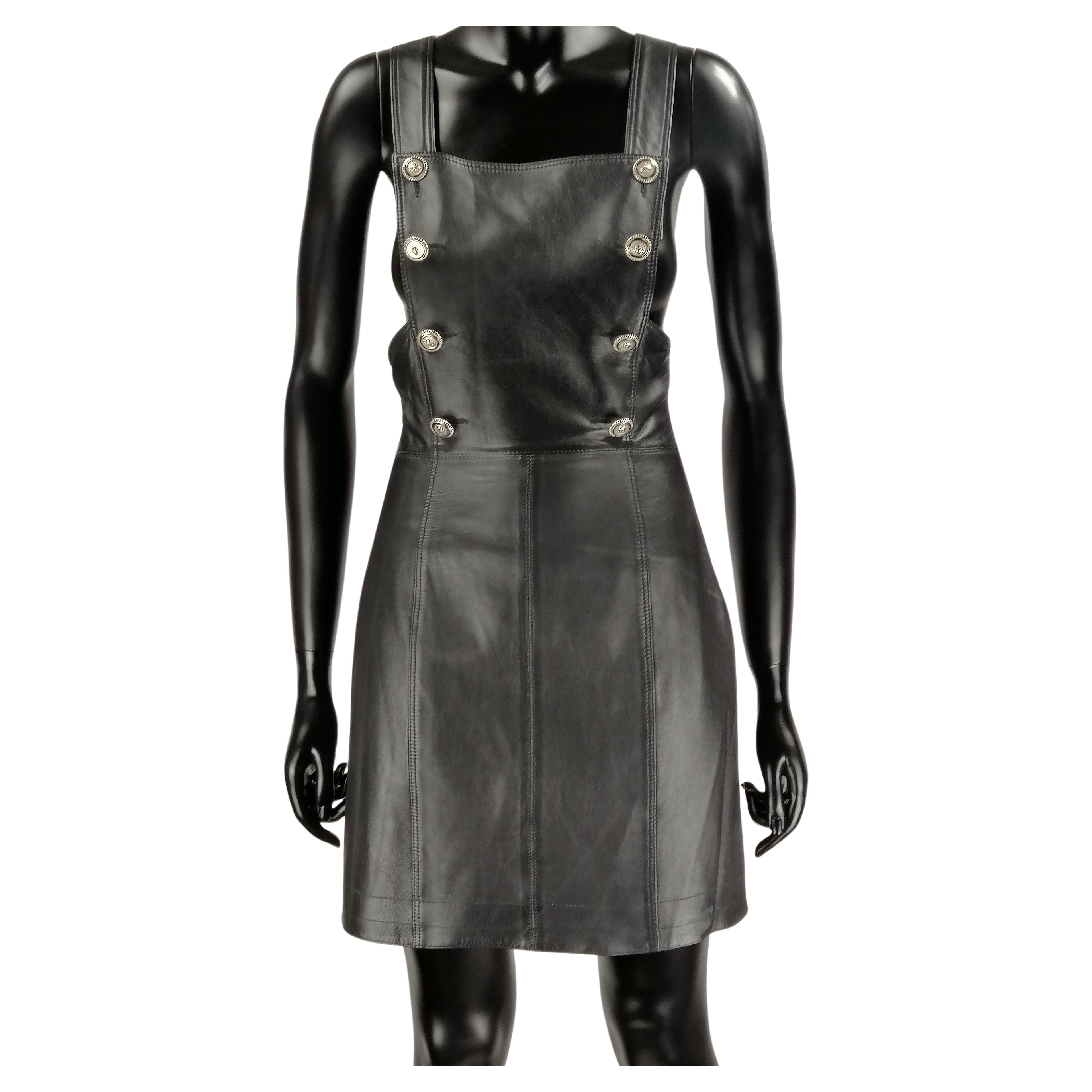 VERSUS Gianni Versace early 1990's
Rare black leather mini dress.
Overalls suspender style design, a-line skirt, side zipper, gunmetal silver lion head  details.
100% leather
Size It 42/ Small
Made in Italy
Flat measures:
Length cm. 86
Waist cm