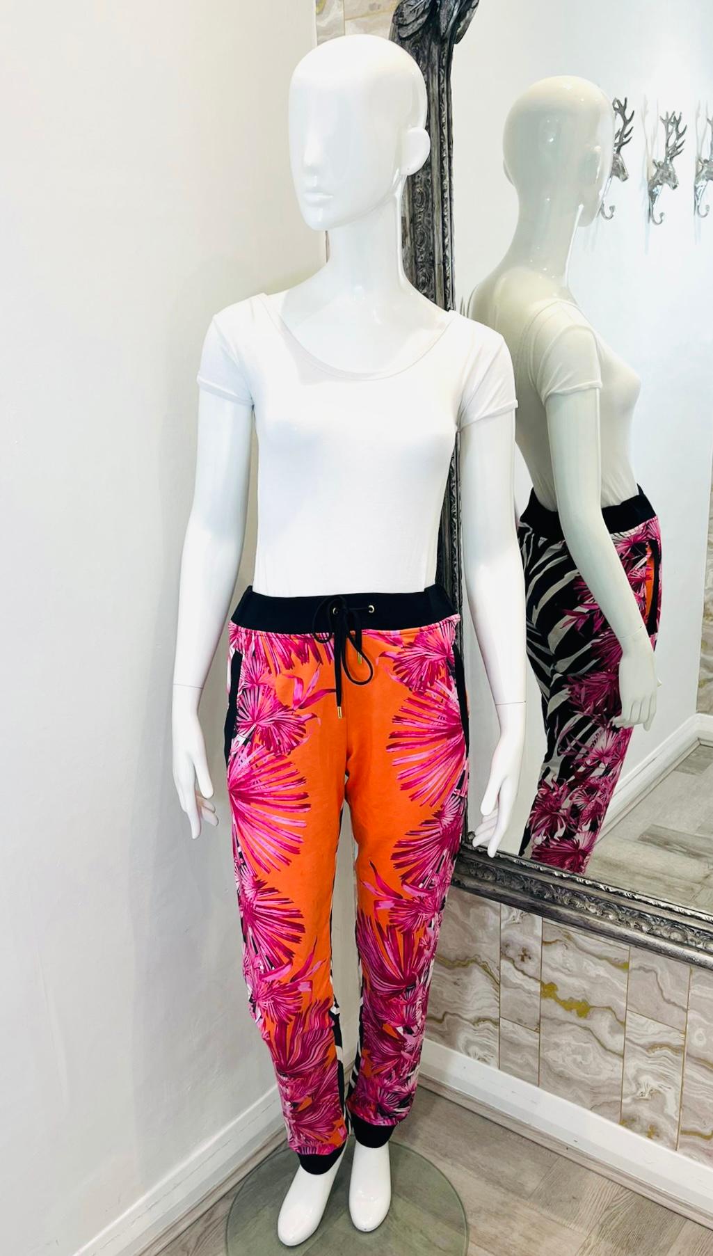 Pantalon en coton imprimé Versus Versace

Pantalon multicolore à la coupe décontractée, orné d'un imprimé floral rose sur le devant et d'un motif zébré contrastant à l'arrière.

Il est doté d'une taille élastique avec cordon de serrage, de poignets
