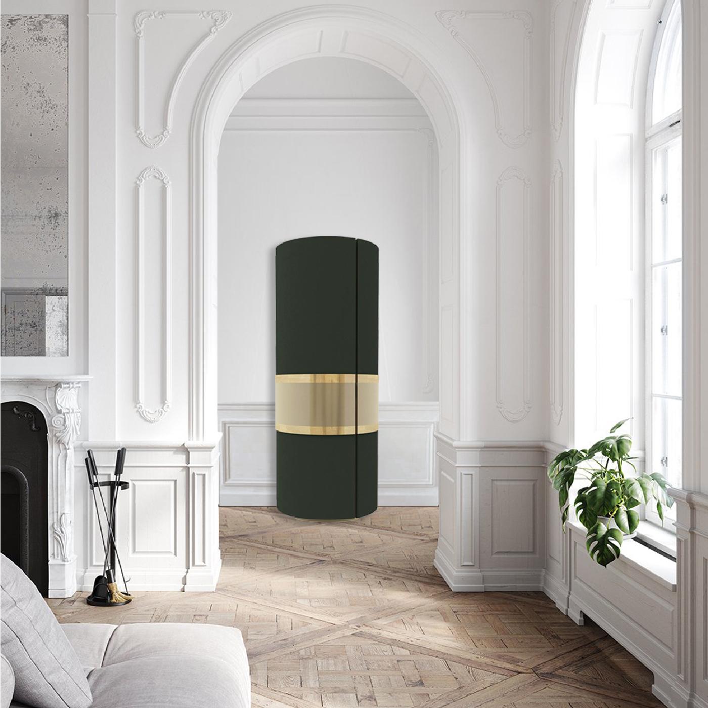A sturdy vertical cylinder, this cabinet will make a bold statement in a modern decor. Ideal to store refined glassware, its elegant sculptural flair is enhanced by the brass central detail boasting a polished gold finish, exquisitely contrasting