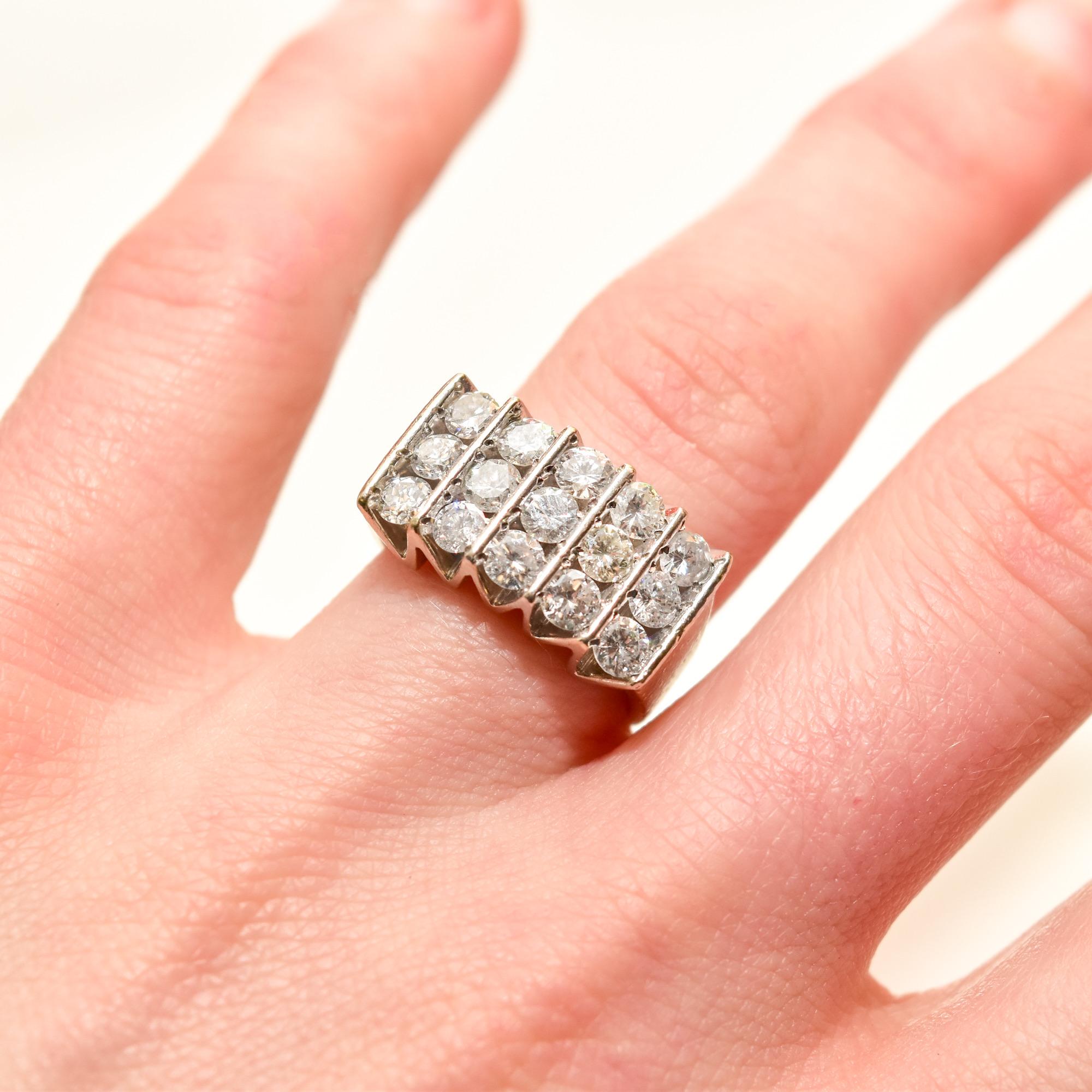 An incredible vertical 5-row diamond ring in 14k white gold. Features 15 brilliant-cut diamonds arranged in 5 vertical channel settings. The gallery boasts a modernist zig-zag design and the ring band has a wide tapered silhouette.   

The inner