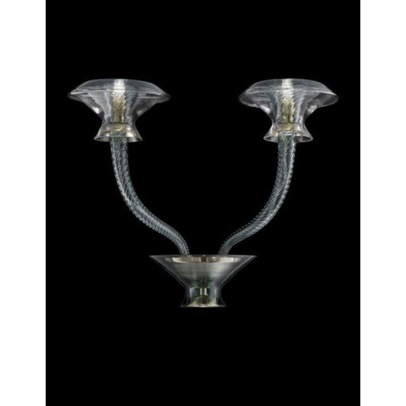 Vertigo is a family of chandeliers and wall sconces that thrives on contrasts, combining dynamism and symmetry, delicacy and power. Its original vertical thrust is attenuated by the radial extension of the arms, softly opening like petals. The main