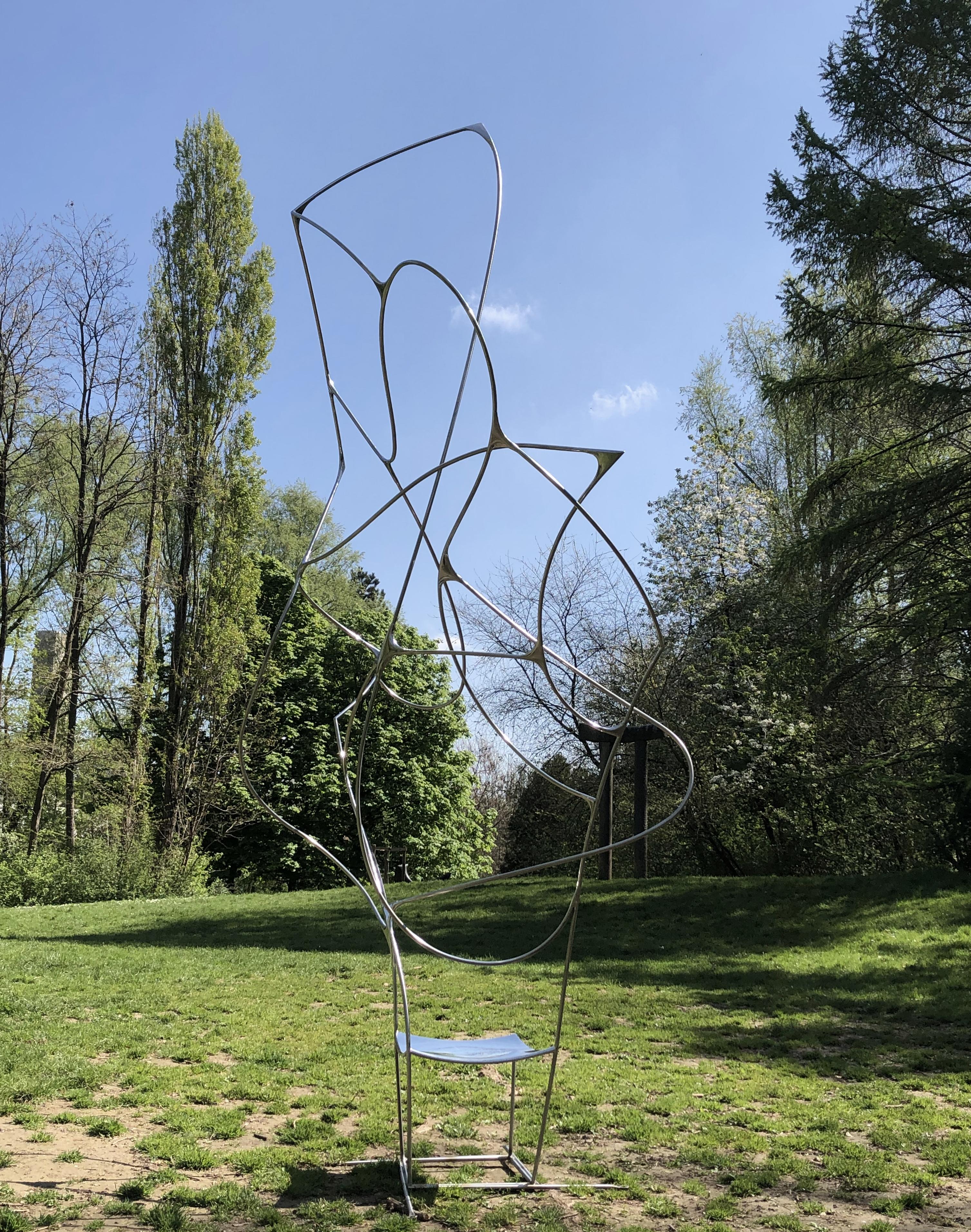Sedia scultorea Vertigo III di Pol Quadens 
Un pezzo unico.
Dimensioni: P 80 x L 120 x H 300 cm.
Materiali: Acciaio inossidabile lucidato.

Pol Quadens è nato a Bruxelles. Suo padre era attivo nel campo dei compositi e dell'industria metallurgica e