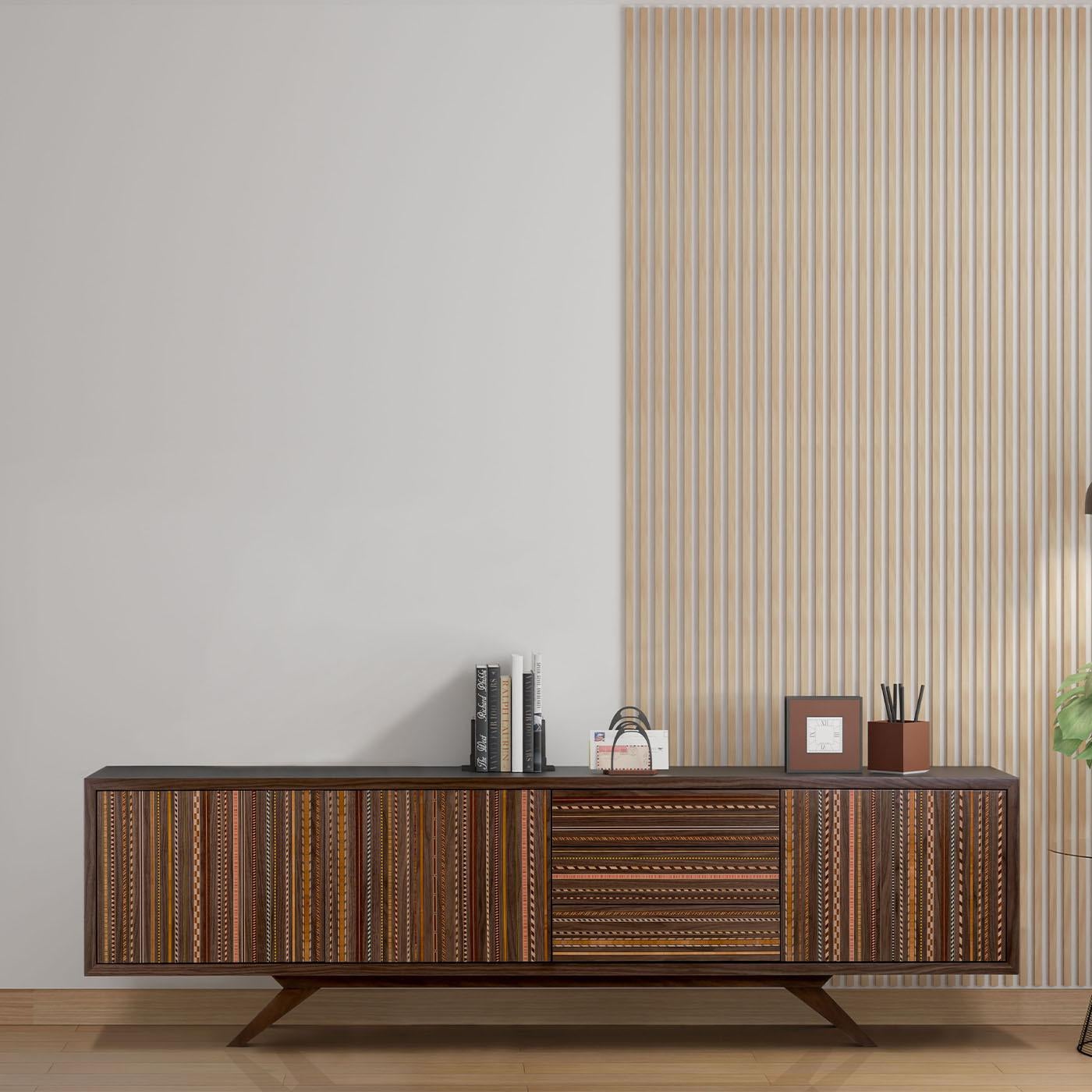 Un trionfo di contrasti audaci, questa robusta credenza in noce è un'aggiunta accattivante agli interni moderni e contemporanei che si desidera valorizzare con un gioiello artigianale che non rinuncia alla funzionalità. Gli eleganti piedini obliqui