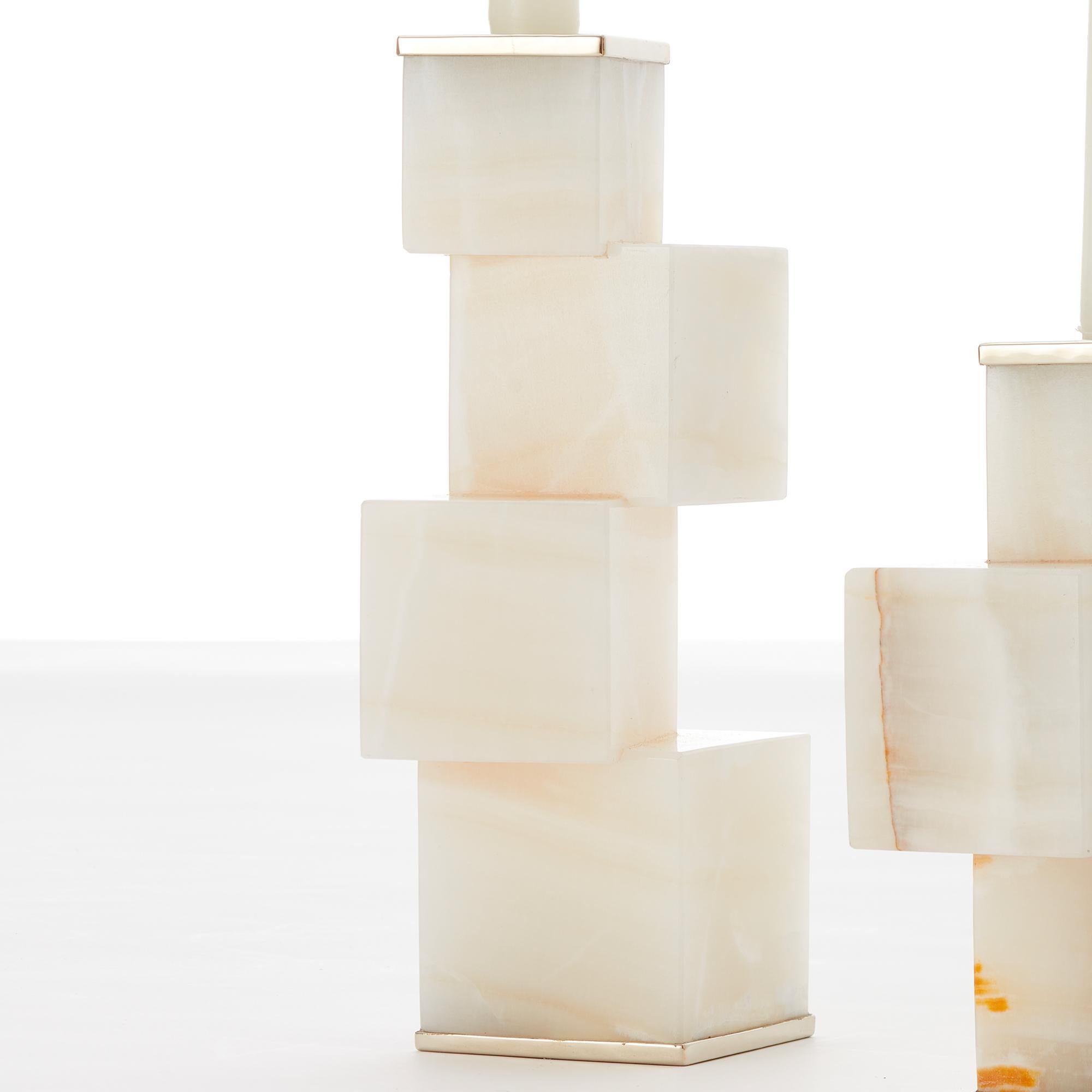 Una composizione di onice e metallo di alpaca. Si ispira alle linee pure ed essenziali di una struttura di pietre solide, con una stabilità da vertigine.

I nostri pezzi sono realizzati a mano. Unico nel suo genere.
Tutte le pietre naturali