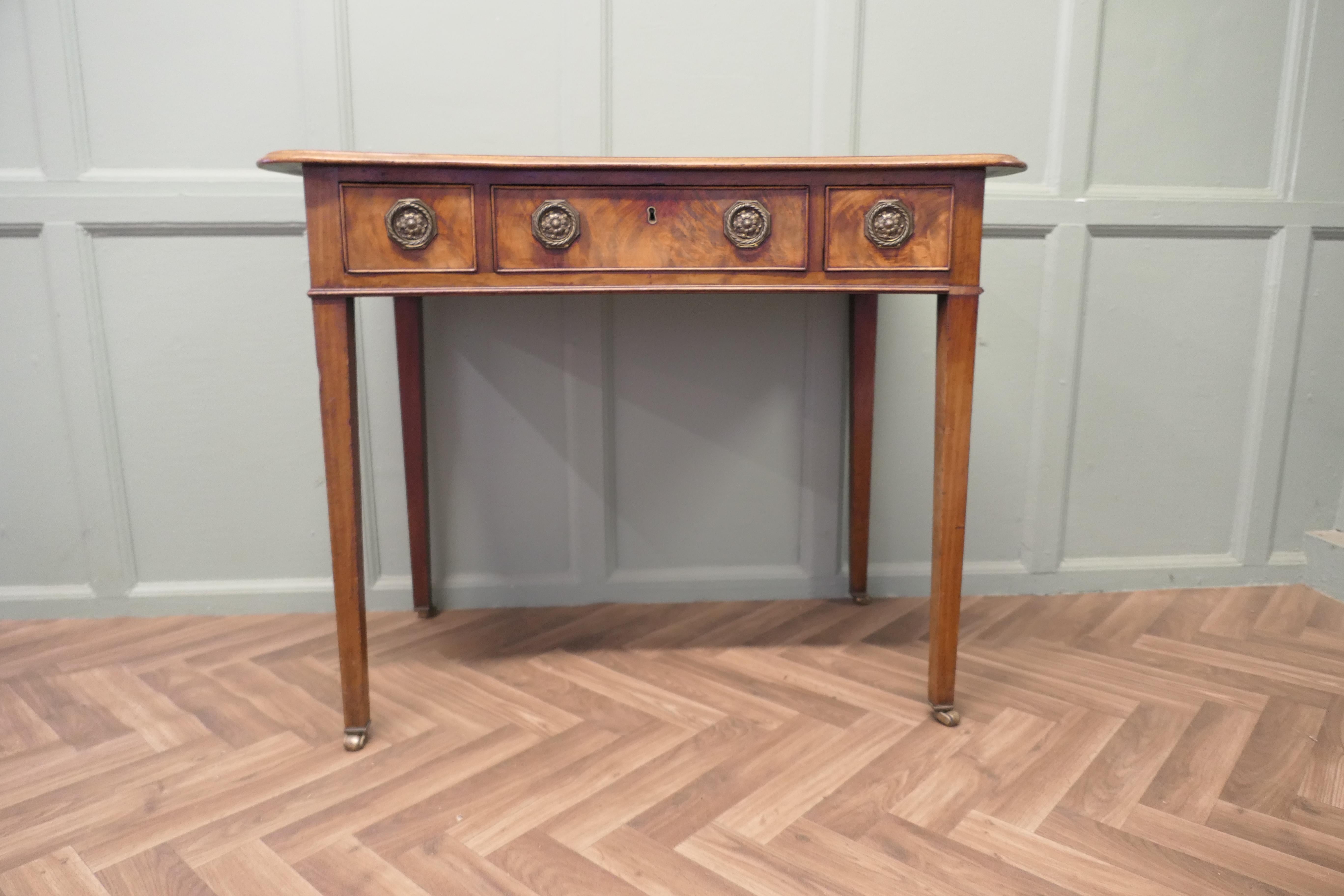 Very Attractive Victorian Walnut Writing or Side Table

This is a very attractive table, it has a very unusual shape withan inward curving front edge, the table has 3 drawers to the front and it stands on long tapering legs with brass casters
This