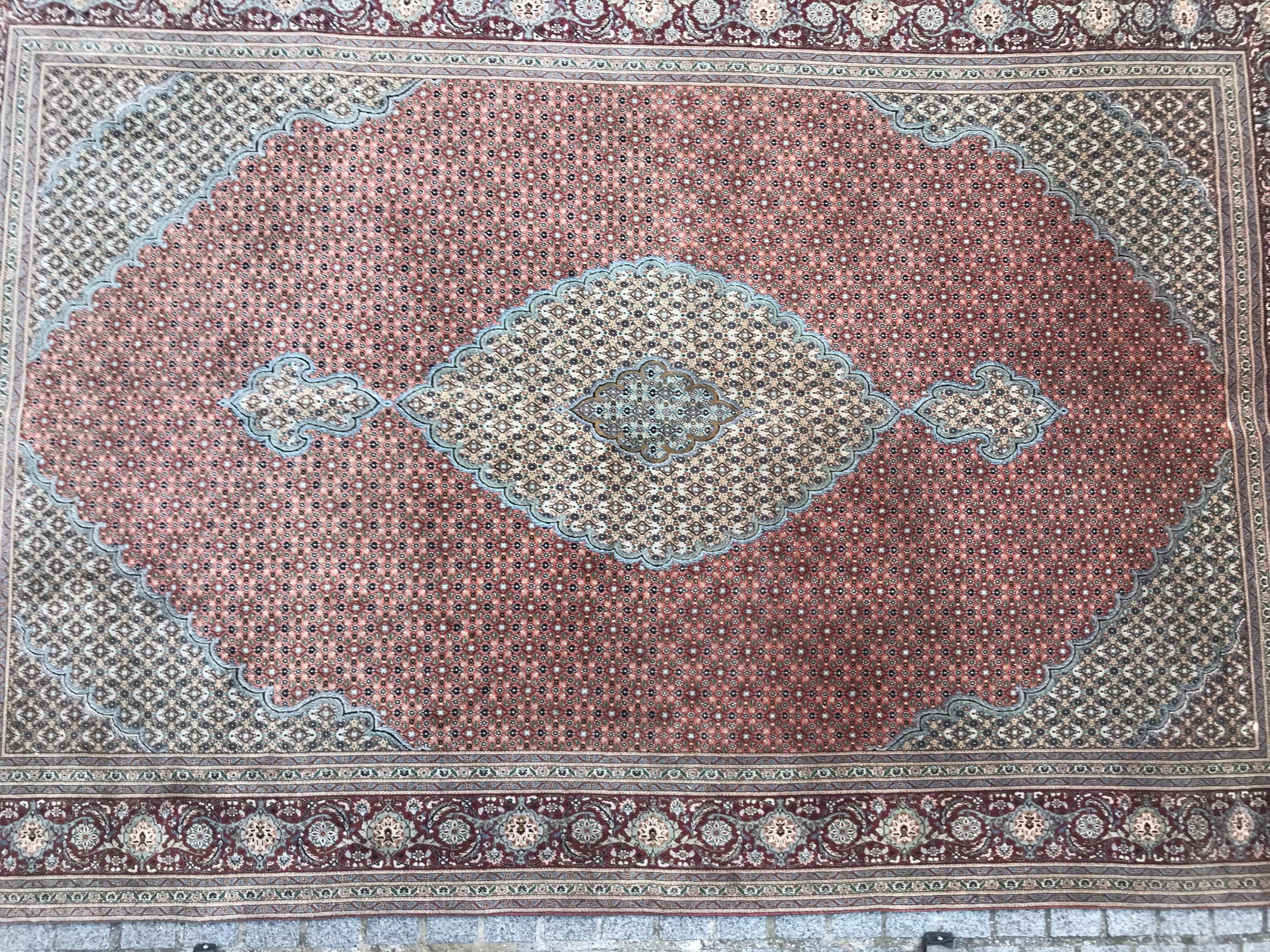 Entdecken Sie die Eleganz unseres exquisiten Teppichs, der durch ein fesselndes Design mit stilisierten Blumen und leuchtenden Farben in Orange, Blau und Grün besticht. Sorgfältig handgeknüpft aus einer Mischung aus Wolle und Seidensamt auf einem