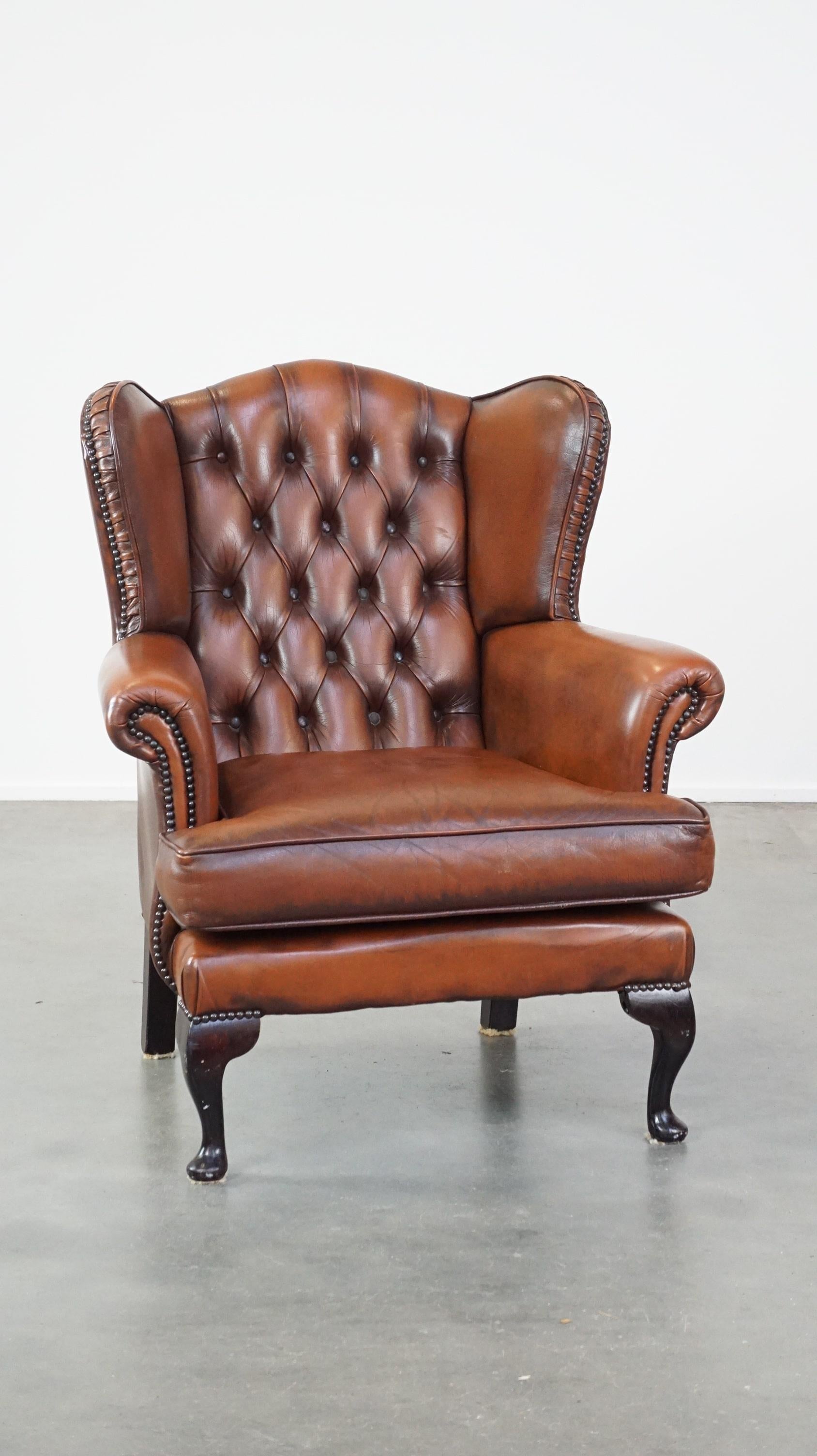 Offered this very beautiful, stately, cowhide chesterfield wing chair with elegant legs in a fine brown color.

This great cowhide wing chair is a real eye-catcher and an asset for every lover of chesterfield furniture. Partly due to its fine brown
