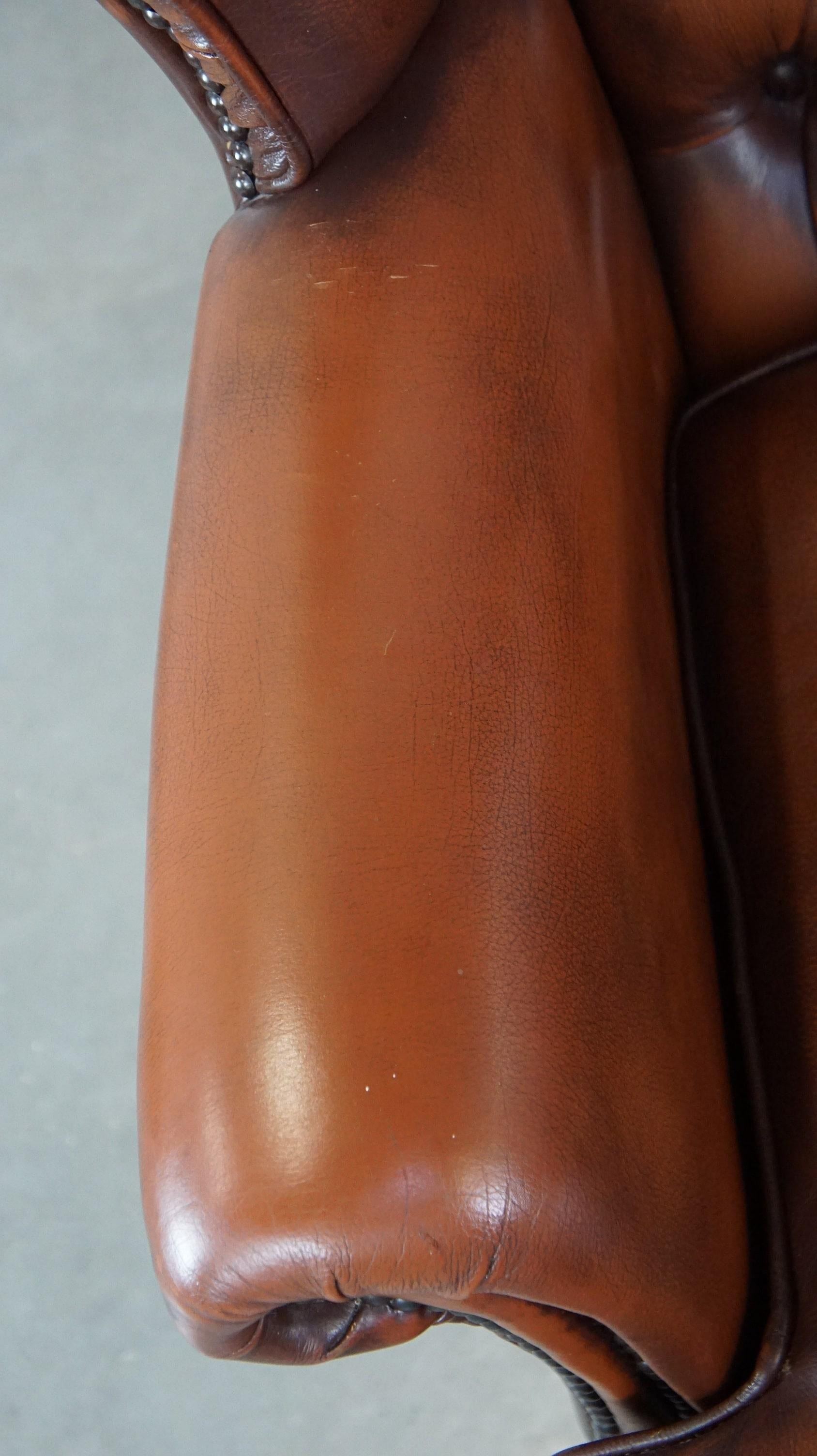 Very beautiful cowhide Chesterfield wing chair with elegant legs in brown color For Sale 1